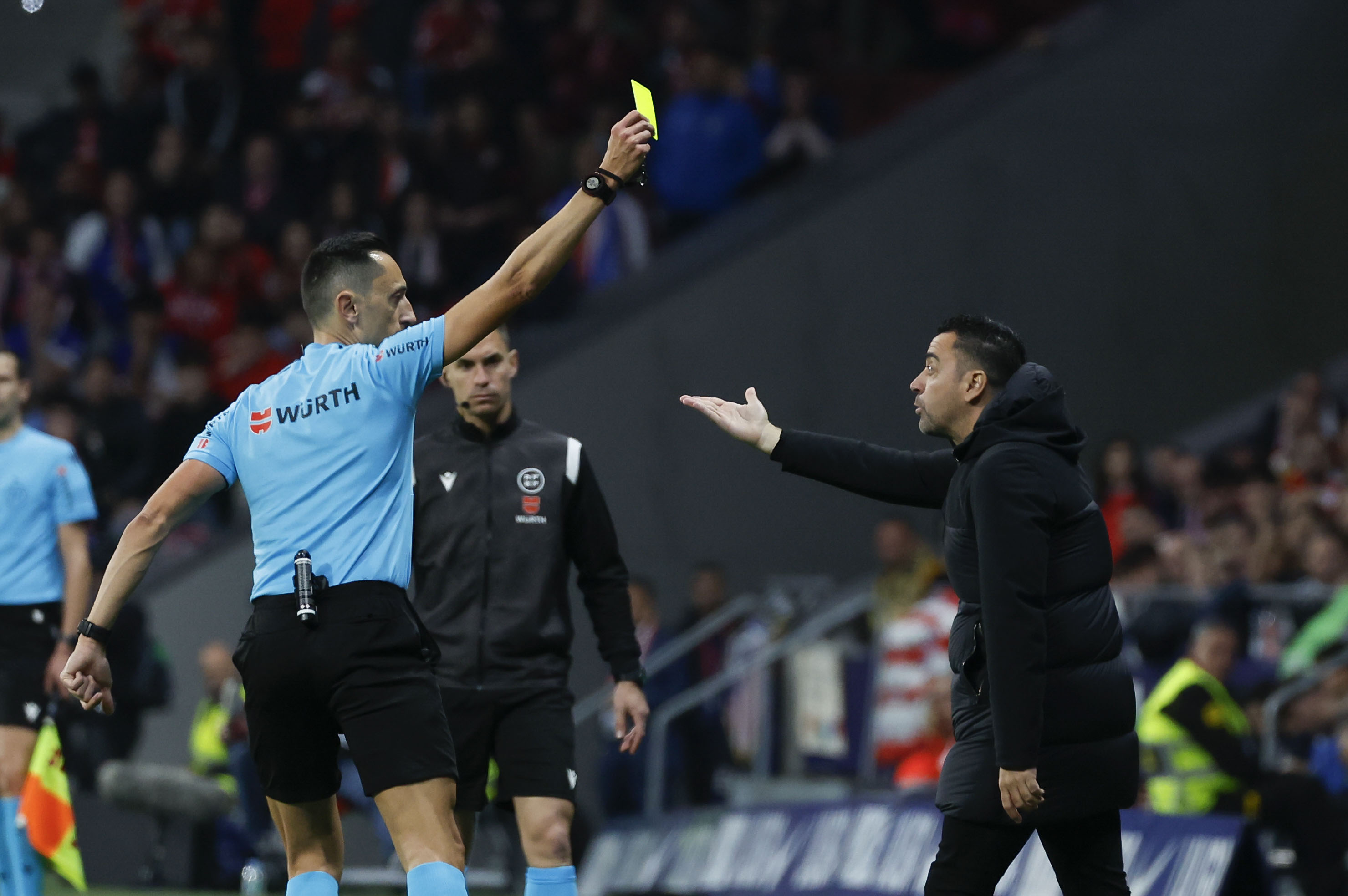 El entrenador del FC Barcelona, Xavi Hernández, es amonestado durante el partido frente al Atlético de Madrid este domingo en el estadio Metropolitano. (Foto Prensa Libre: EFE)