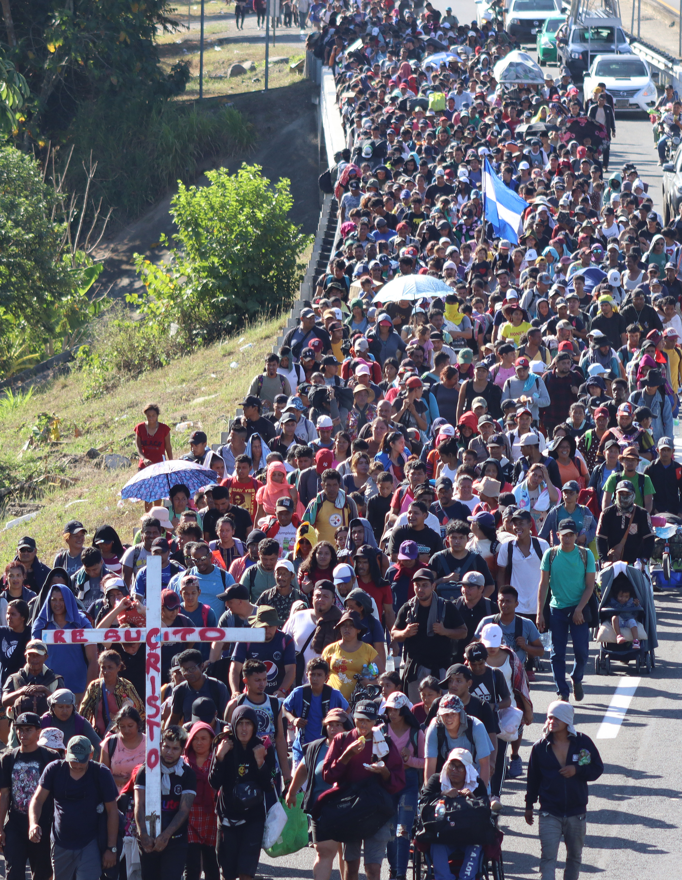 MEX2985. VILLA COMATITLÁN (MÉXICO), 27/03/2024.- Migrantes que integran el 'Viacrusis migrante' caminan en caravana este miércoles, en el municipio de Villa Comatitlán en el estado Chiapas (México). Migrantes de Venezuela, Ecuador y Colombia, que forman parte del Viacrucis migrante que transita del sur de México hacia la capital del país, rechazaron este miércoles querer retornar a sus países y recibir los 110 dólares mensuales que ofrece el gobierno mexicano como parte de una estrategia para frenar la migración. EFE/Juan Manuel Blanco