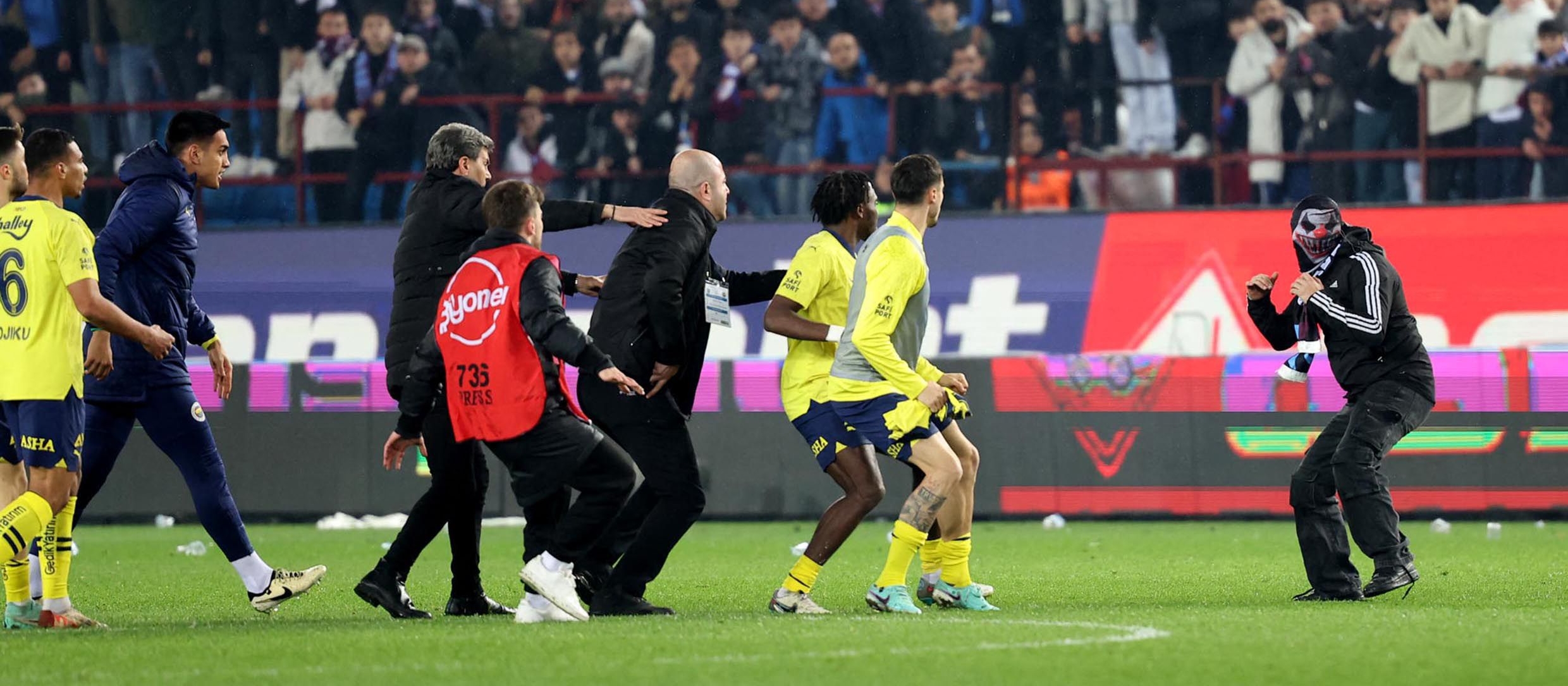 Jugadores del Fenerbahce, siendo increpados por los aficionados del equipo rival, el Trabzonspor en el estadio Papara Park de Turquía. (Foto Prensa Libre: AFP)