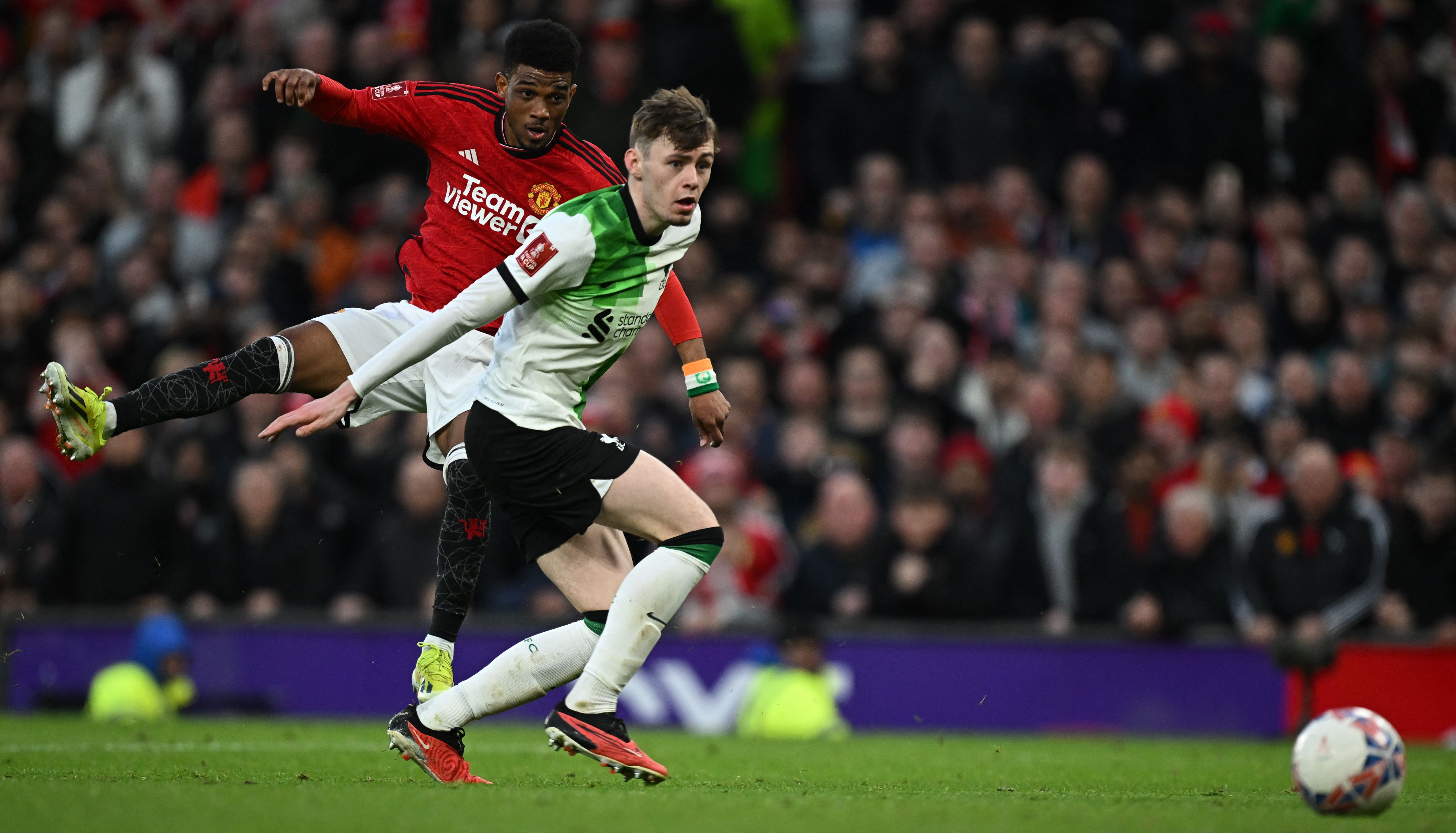 El momento en que el jugador del Manchester United, Amad Diallo (rojo), anota el cuarto gol de su equipo ante el Liverpool en Old Trafford. (Foto Prensa Libre: AFP)