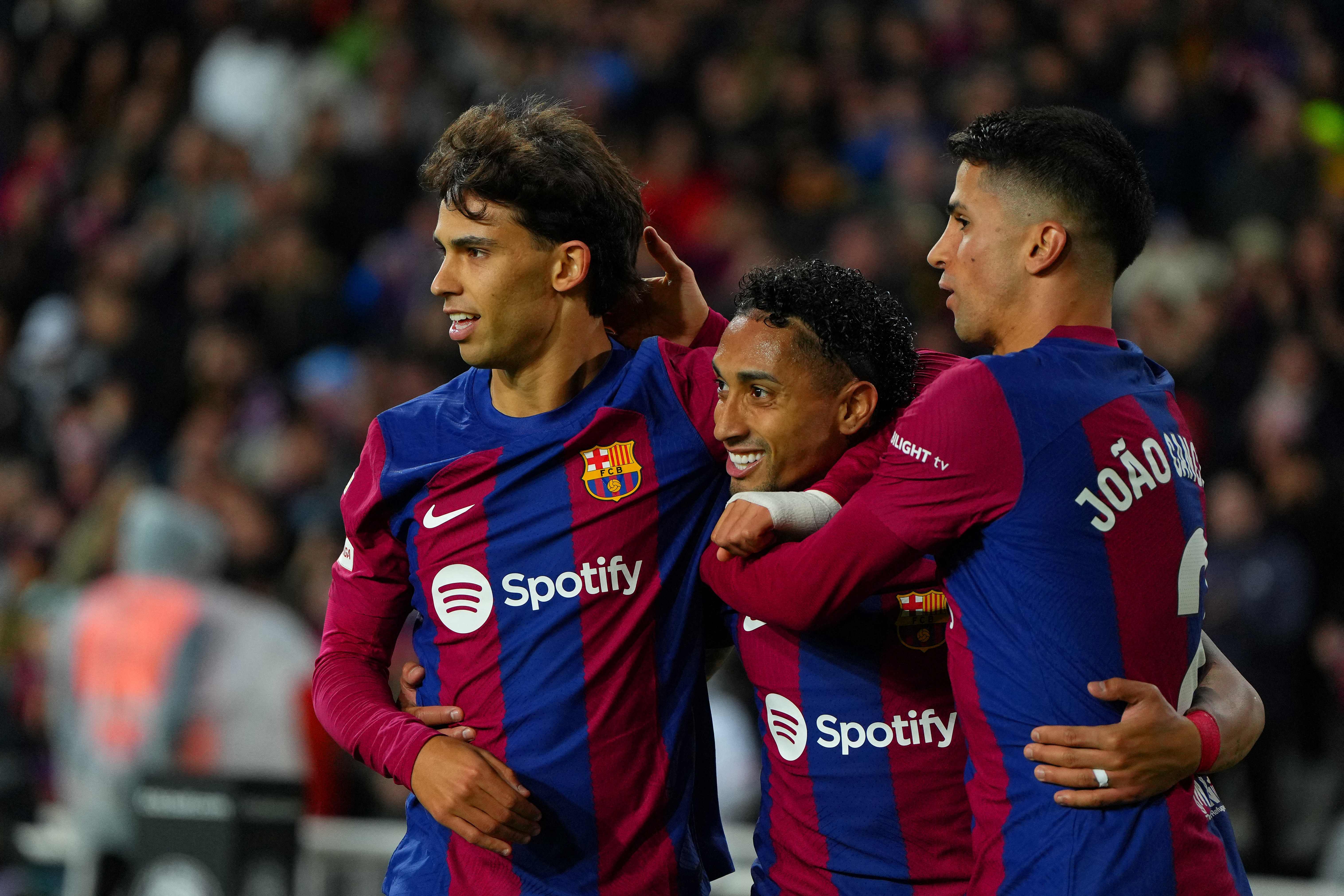 Los jugadores del Barcelona, Joao Felix (izq) celebra con su compañero, Joao Cancelo, después de marcarle a la UD Las Palmas en el estadio Olimpic Lluis Companys de Barcelona el 30 de marzo pasado. (Foto Prensa Libre: AFP)