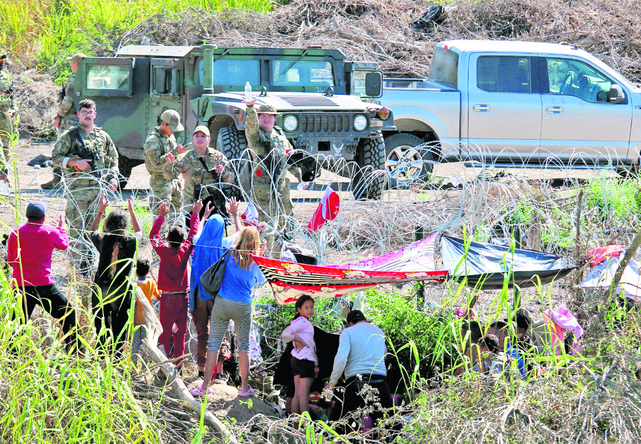 MEX6437. MATAMOROS (MÉXICO),25/09/2023.- Migrantes son retenidos por La Guardia Nacional estadounidense al cruzar el Río Bravo para intentar ingresar a Estados Unidos hoy, en Matamoros (México). La Guardia Nacional estadounidense retienen a migrantes venezolanos que cruzaron el fronterizo río Bravo (río Grande en EE.UU.) en el norte de México, dejándolos con raciones de agua limitada y sin comida por casi un día, denunciaron este lunes migrantes y activistas en la ciudad mexicana de Matamoros, estado de Tamaulipas. EFE/Abrahan Pineda-Jacome