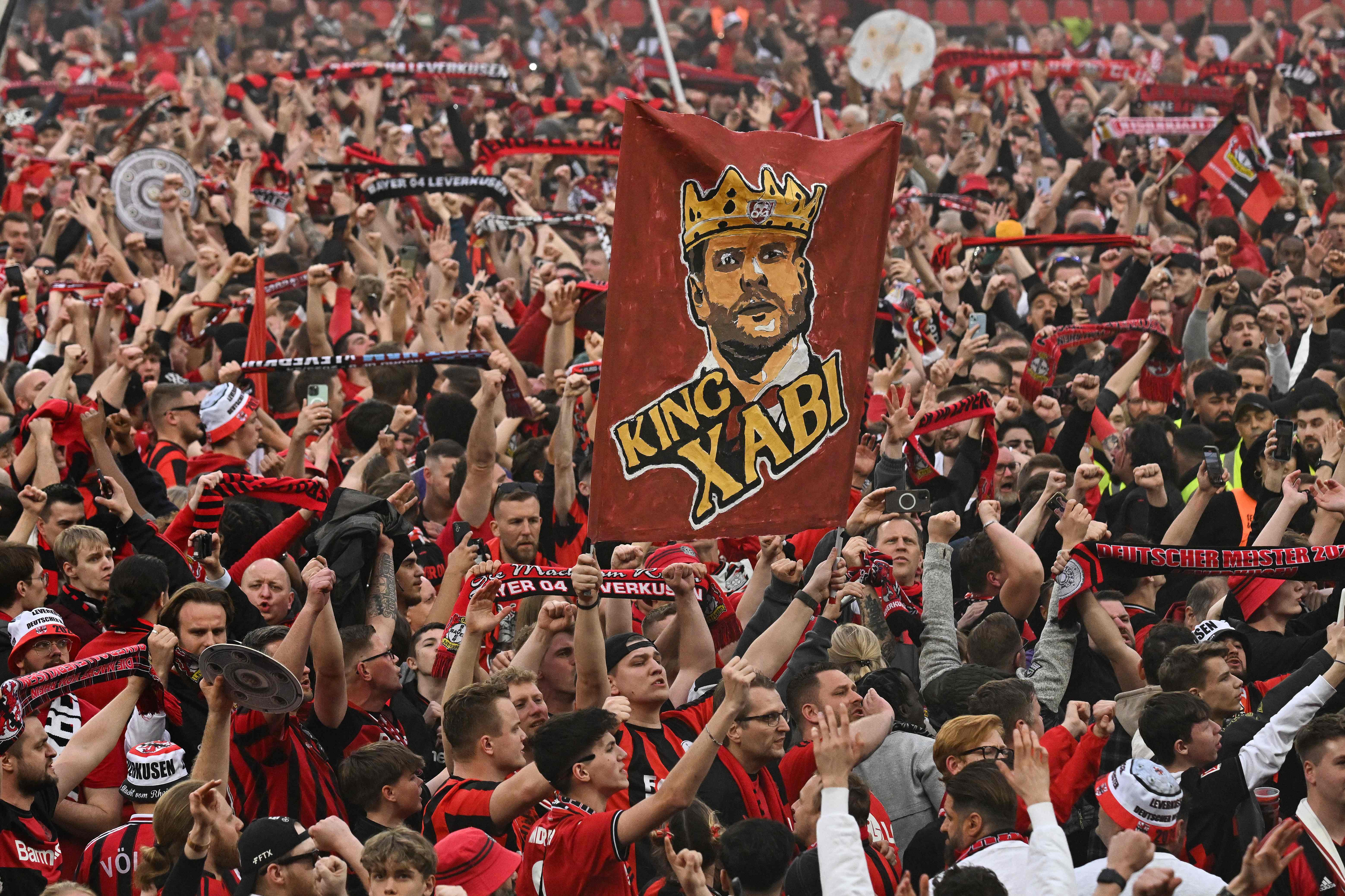 Los fans del Leverkusen invaden la cancha celebrando el festejo de la Bundesliga con una pancarta que dice "Rey Xavi", en honor de su entrenador, Xabi Alonso.(Foto Prensa Libre: AFP)