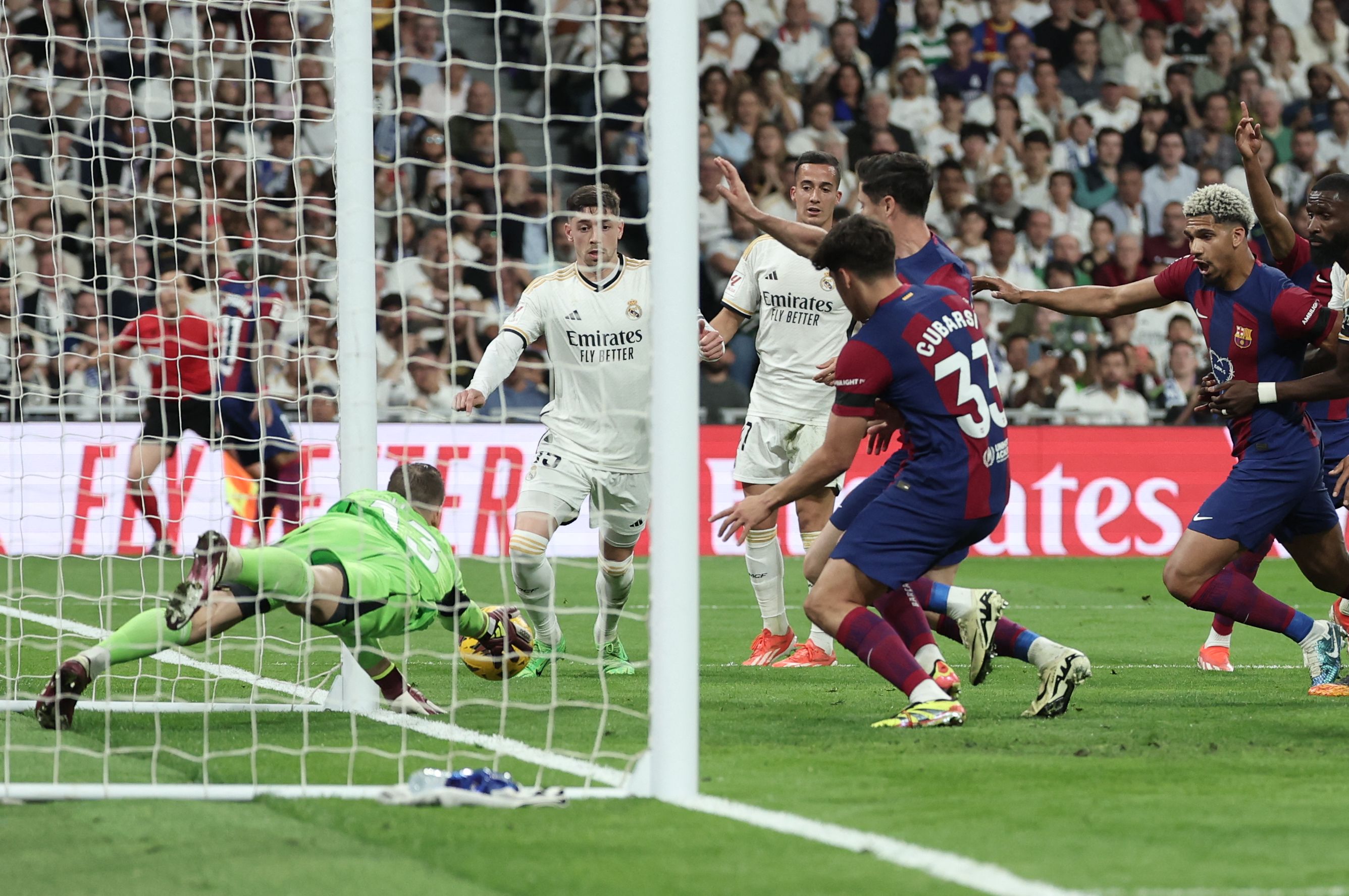 El portero del Real Madrid, Andriy Lunin, ataja el balón de la polémica tras un disparo del jugador del Barcelona, Lamine Yamal. (Foto Prensa Libre: AFP)