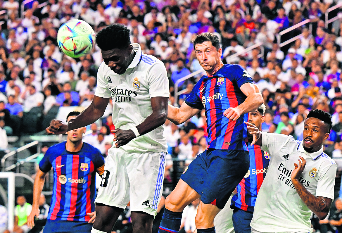 TOPSHOT - Barcelona's Robert Lewandowski (R) looks on as Real Madrid's Aurelien Tchouameni heads the ball during the international friendly football match between Barcelona and Real Madrid at Allegiant Stadium in Las Vegas, Nevada, on July 23, 2022. (Photo by Frederic J. BROWN / AFP)