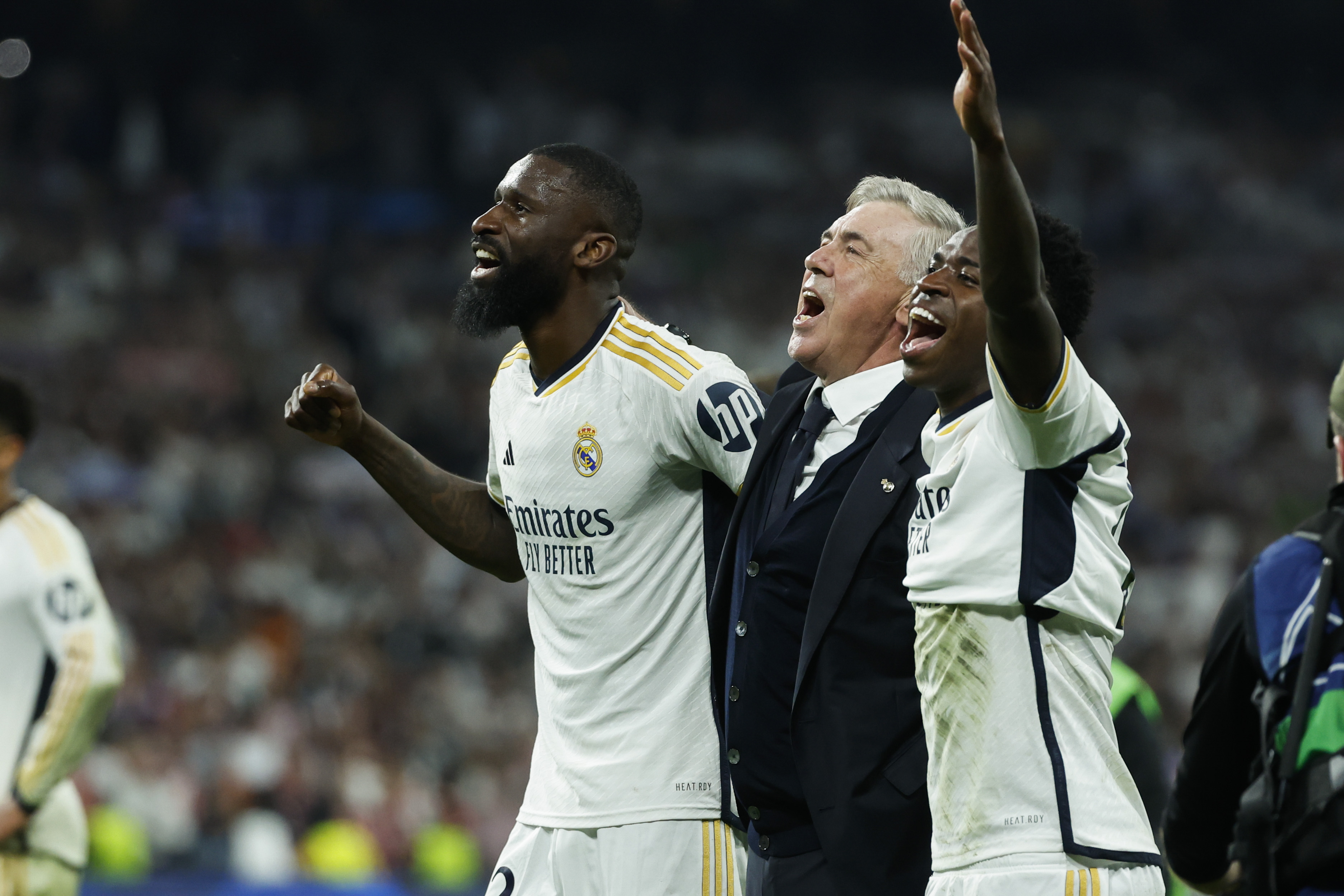 El jugador alemán, Antonio Rudiger, junto a su entrenador en el Real Madrid, Carlo Ancelotti y Vinicius Jr. celebran la victoria tras el partido de vuelta de las semifinales de la Liga de Campeones ante el FC Bayern. (Foto Prensa Libre: EFE)