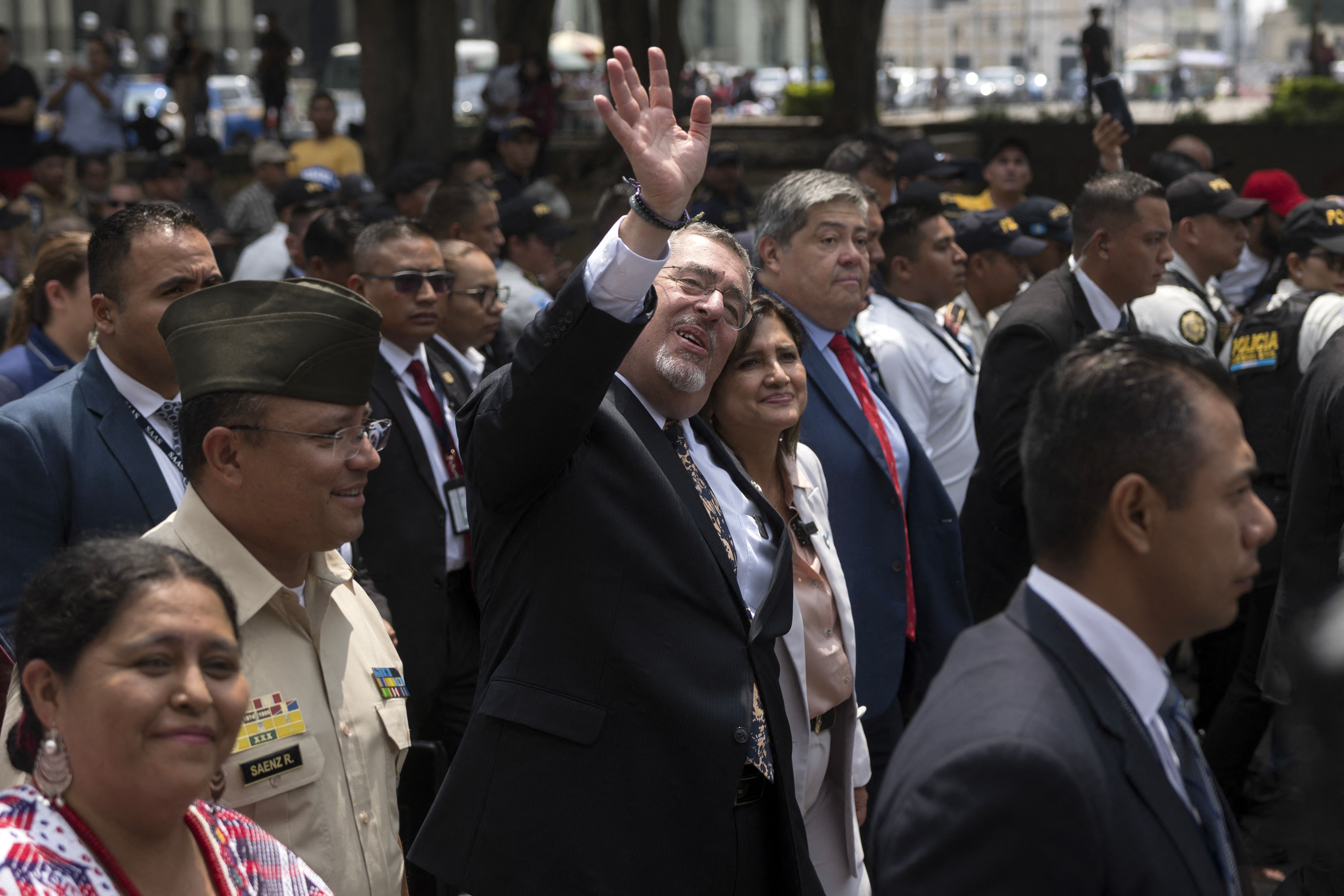 Guatemalan President Bernardo Arevalo (C) waves next to Vice-President Karin Herrera (C, right) while they head with Defence Minister Henry Saenz (L) and Interior Minister Francisco Jimenez (next to Herrera) to the Congress to present legal reforms that would allow the removal of the country's top prosecutor, in Guatemala City on May 6, 2024. Arevalo headed to Congress to present legal reforms that would allow the removal of Attorney general Consuelo Porras, who he accuses of plotting to oust him. Porras, who is under US and EU sanctions for corruption, was appointed by Arevalo's predecessor and led efforts to have the newcomer's election victory overturned. Her mandate runs until May 2026, and Arevalo cannot legally fire her without showing just cause under the current law. (Photo by Edwin BERCIAN / AFP)