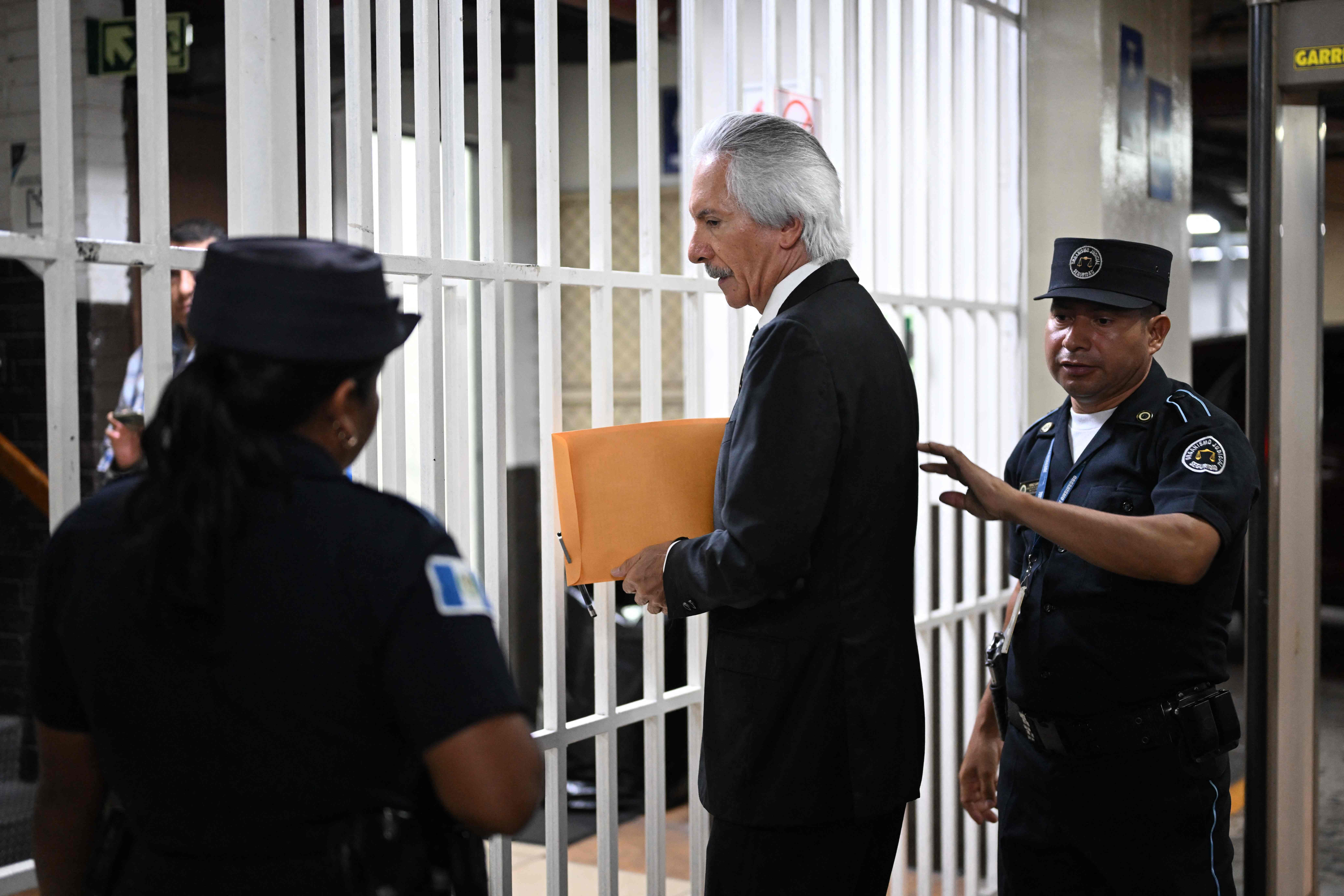 Guatemalan journalist Jose Ruben Zamora, founder of the now defunct newspaper El Periódico, arrives handcuffed for a hearing at the Justice Palace in Guatemala City on May 15, 2024. Zamora, 67, who had been arrested in 2022 and sentenced in 2023 to six years for money laundering, was granted conditional release. (Photo by JOHAN ORDONEZ / AFP)