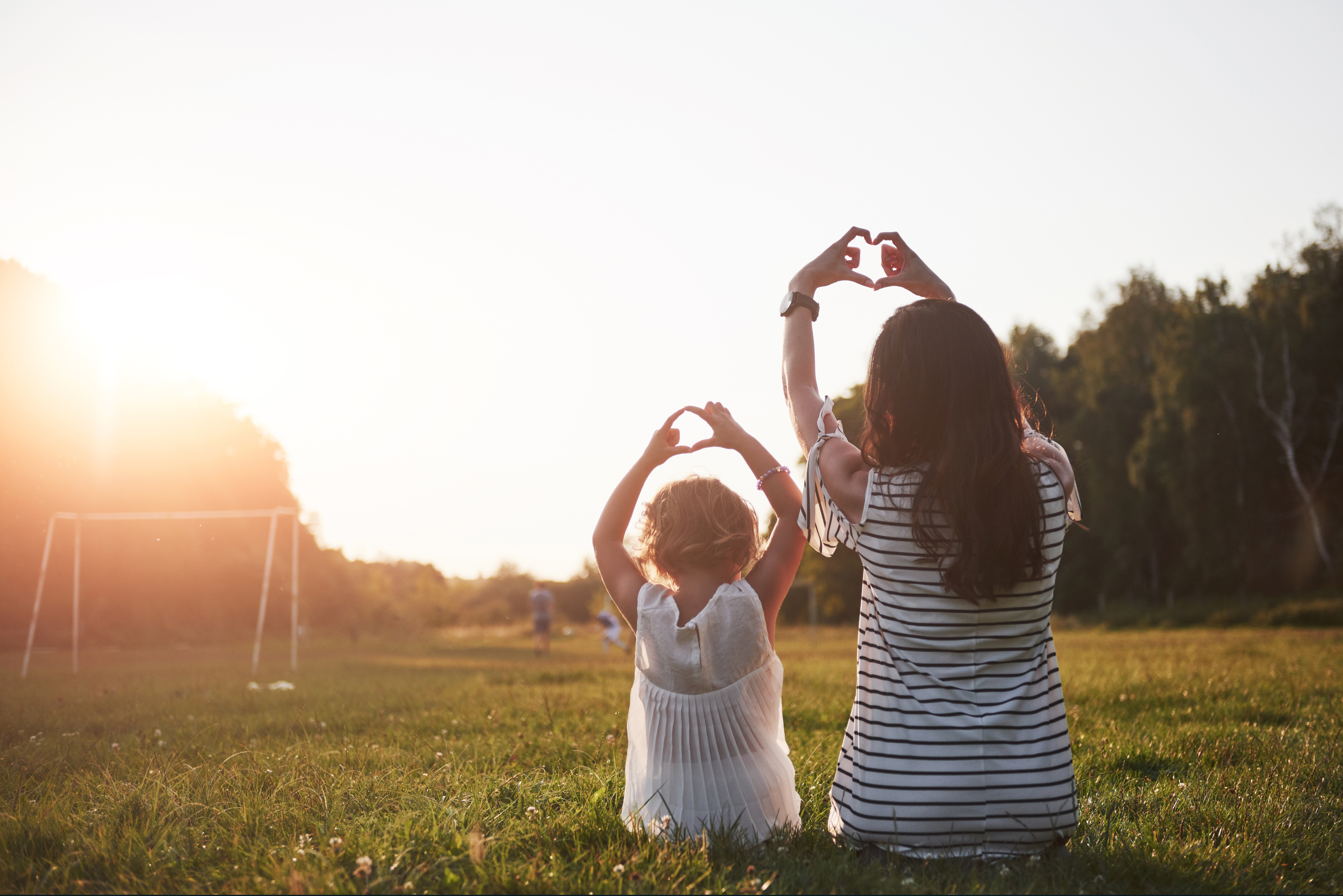 Portrait of a mother and her girl make up her heart in the park