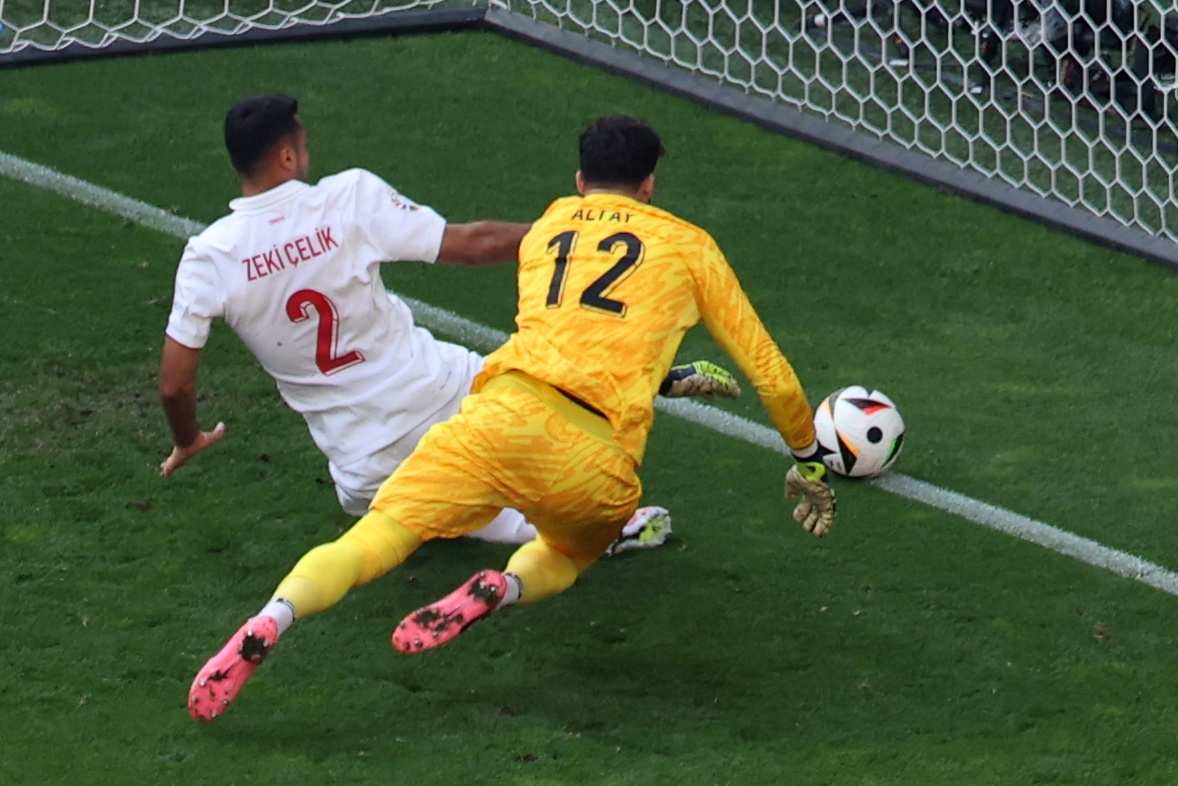 El portero turco, Altay Bayindir y su compañero, en la defensa, Mehmet Zeki Celik, tratan de evitar el autogol de Samet Akaydin, ante Portugal. (Foto Prensa Libre: EFE)