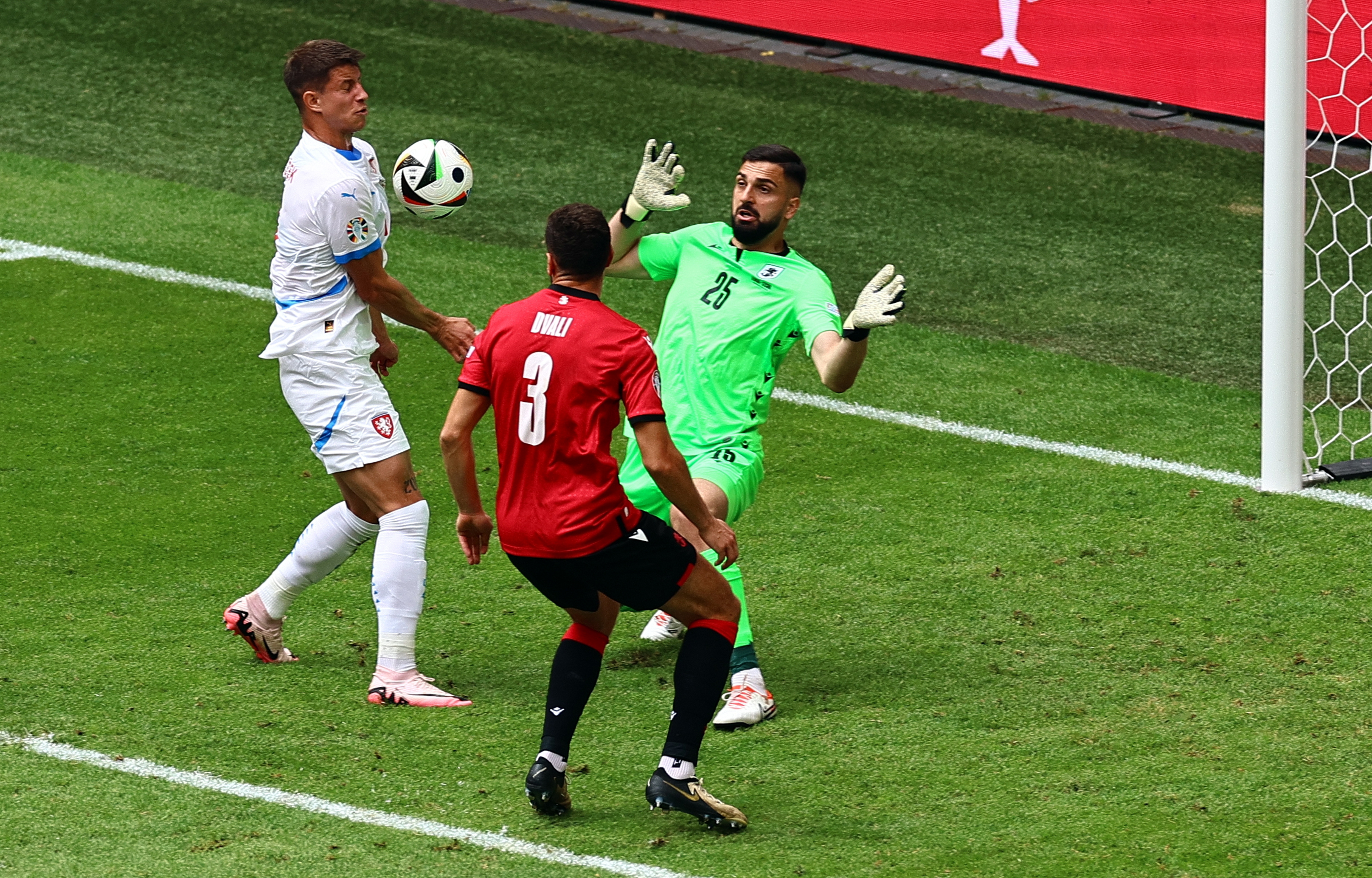 El jugador checo, Adam Hlozek, anota un gol con la cara y luego la mano, frente al portero, Giorgi Mamardashvili, de Georgia. (Foto Prensa Libre: EFE)