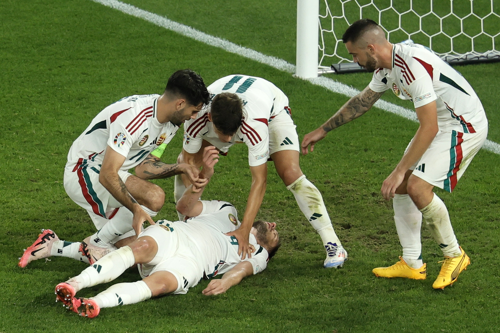 Los jugadores de Hungría se preocupan por la lesión de su compañero, Barnabas Varga, durante el partido ante Escocia. (Foto Prensa Libre: EFE)