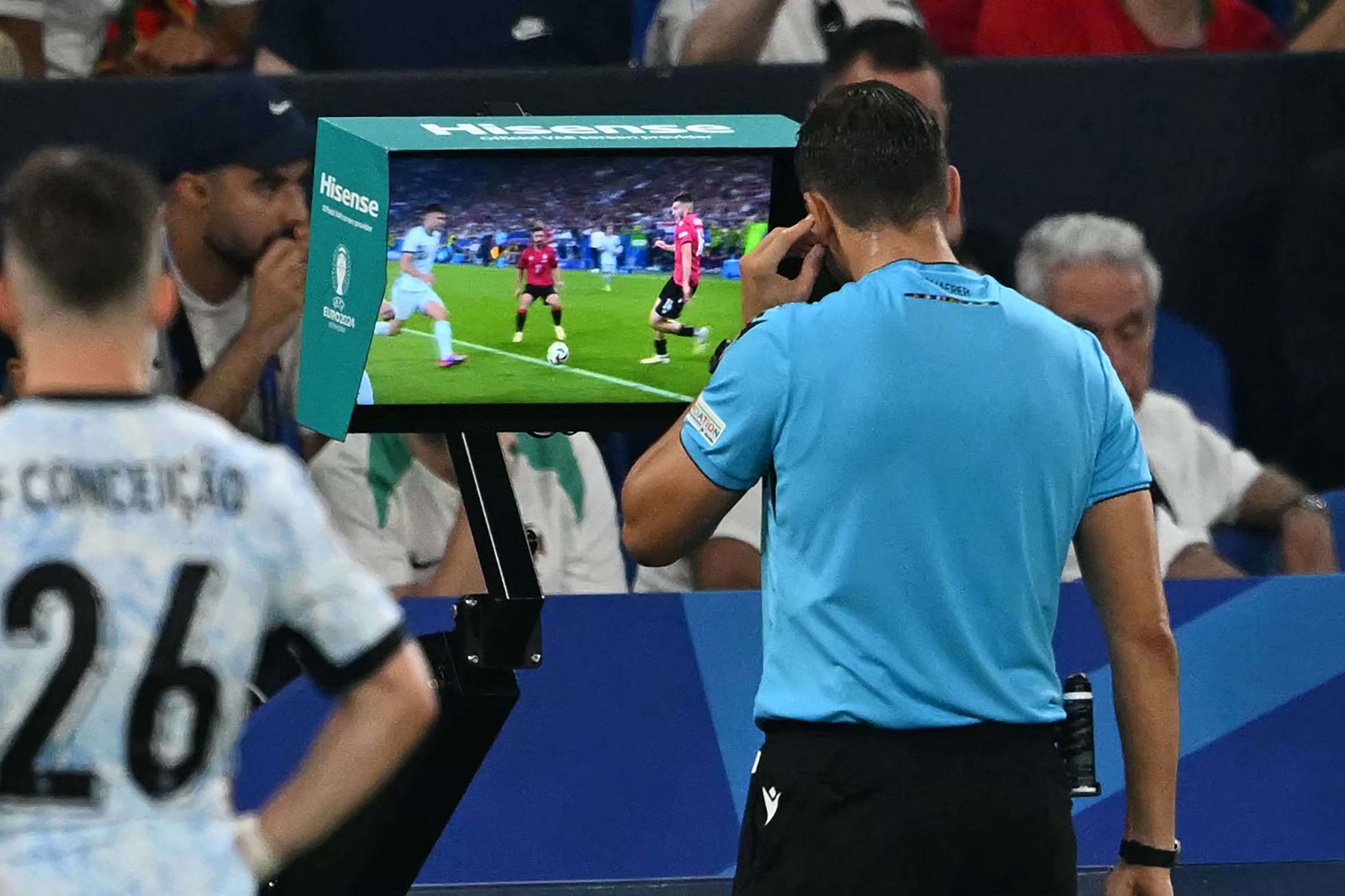 Swiss referee Sandro Schaerer checks the VAR and concedes a penalty for Georgia during the UEFA Euro 2024 Group F football match between Georgia and Portugal at the Arena AufSchalke in Gelsenkirchen on June 26, 2024. (Photo by OZAN KOSE / AFP)