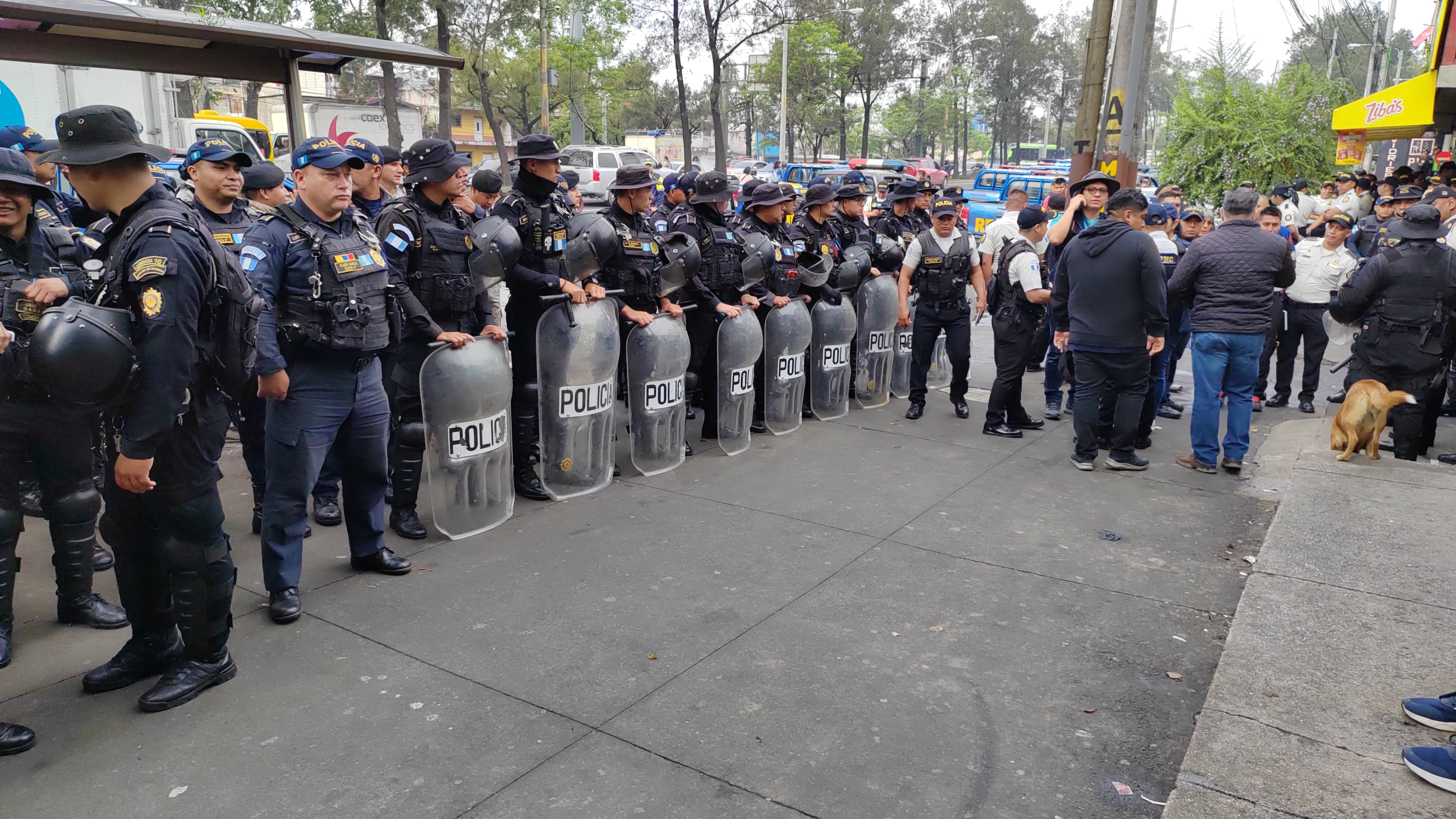 Agentes de la PNC coordinan un desalojo en el asentamiento Dios es Fiel, bajo el puente El Naranjo. (Foto Prensa Libre: O. Vásquez)