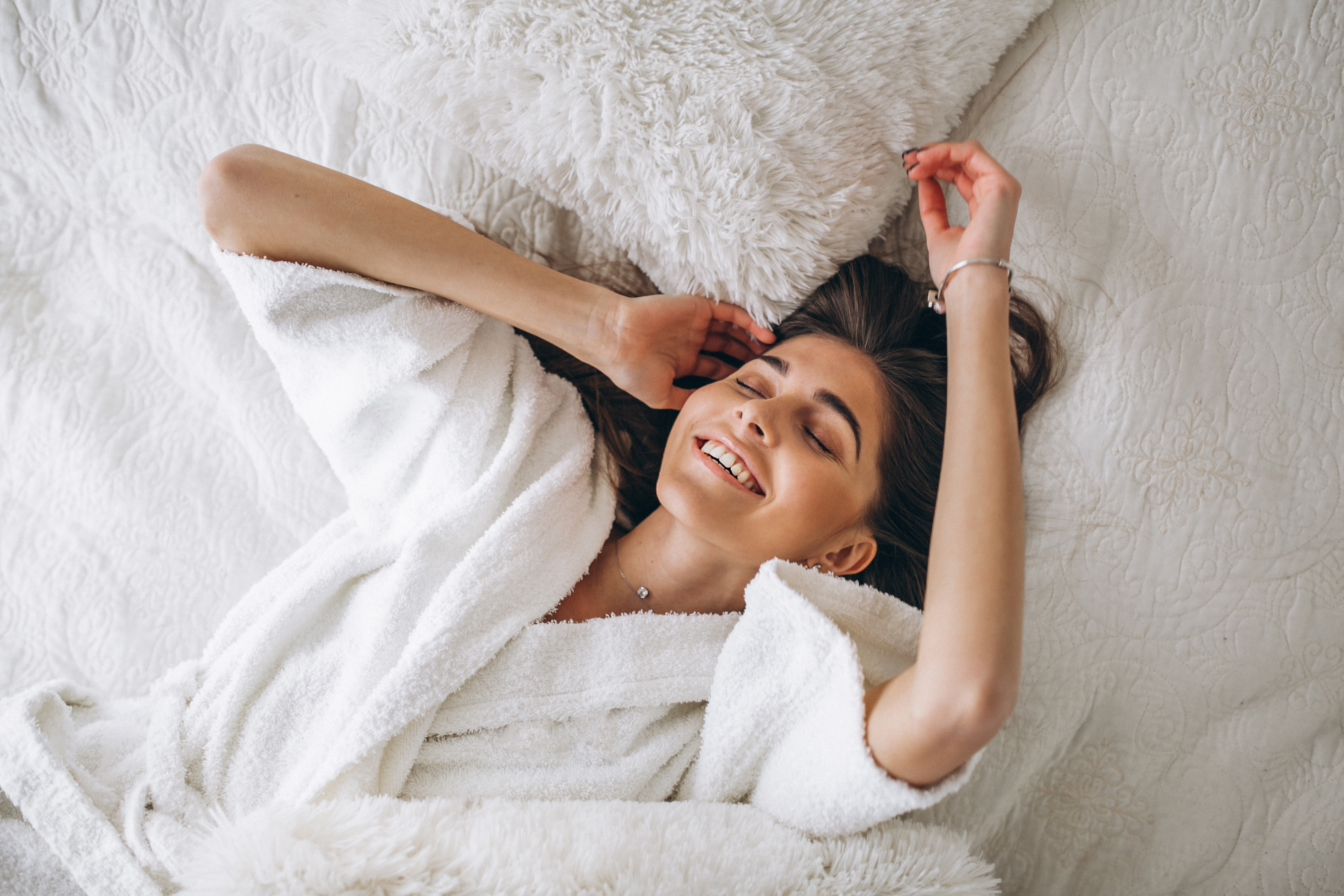 Young woman stretching in bed