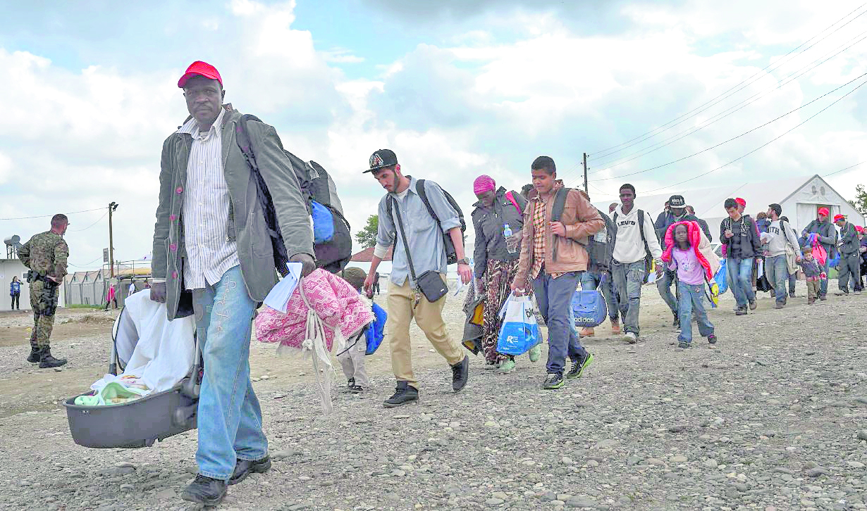 GEO22 GEVGELIJA (MACEDONIA) 19/10/2015.- Un grupo de refugiados cruzando la frontera con Grecia, en Gevgelija, Rep˙blica de Macedonia, hoy 19 de octubre 2015. Miles de migrantes contin˙an llegando a Macedonia en su camino hacia Europa. Los servicios municipales de la pequeÒa poblaciÛn de Gevgelija reconocen estar desbordados ante las masivas llegadas. Europa est· sufriendo la mayor ola de inmigrantes registrada desde la Segunda Guerra mundial, y se calcula que m·s de la mitad de los desplazados provienen de Siria. EFE/Georgi Licovski