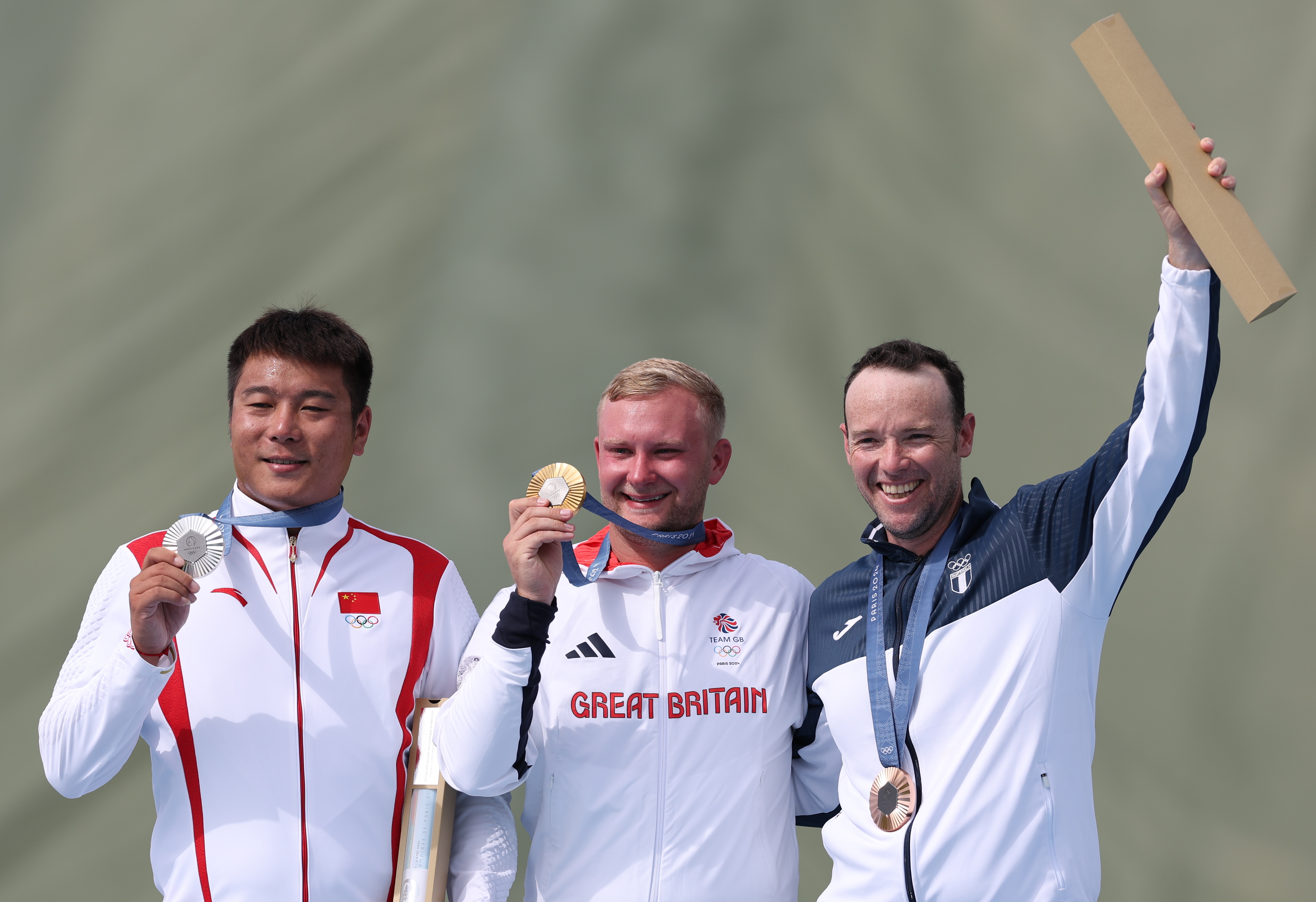 Jean Pierre Brol (derecha) al lado de los otros dos medallistas que se consagraron en la prueba de foso olímpico.