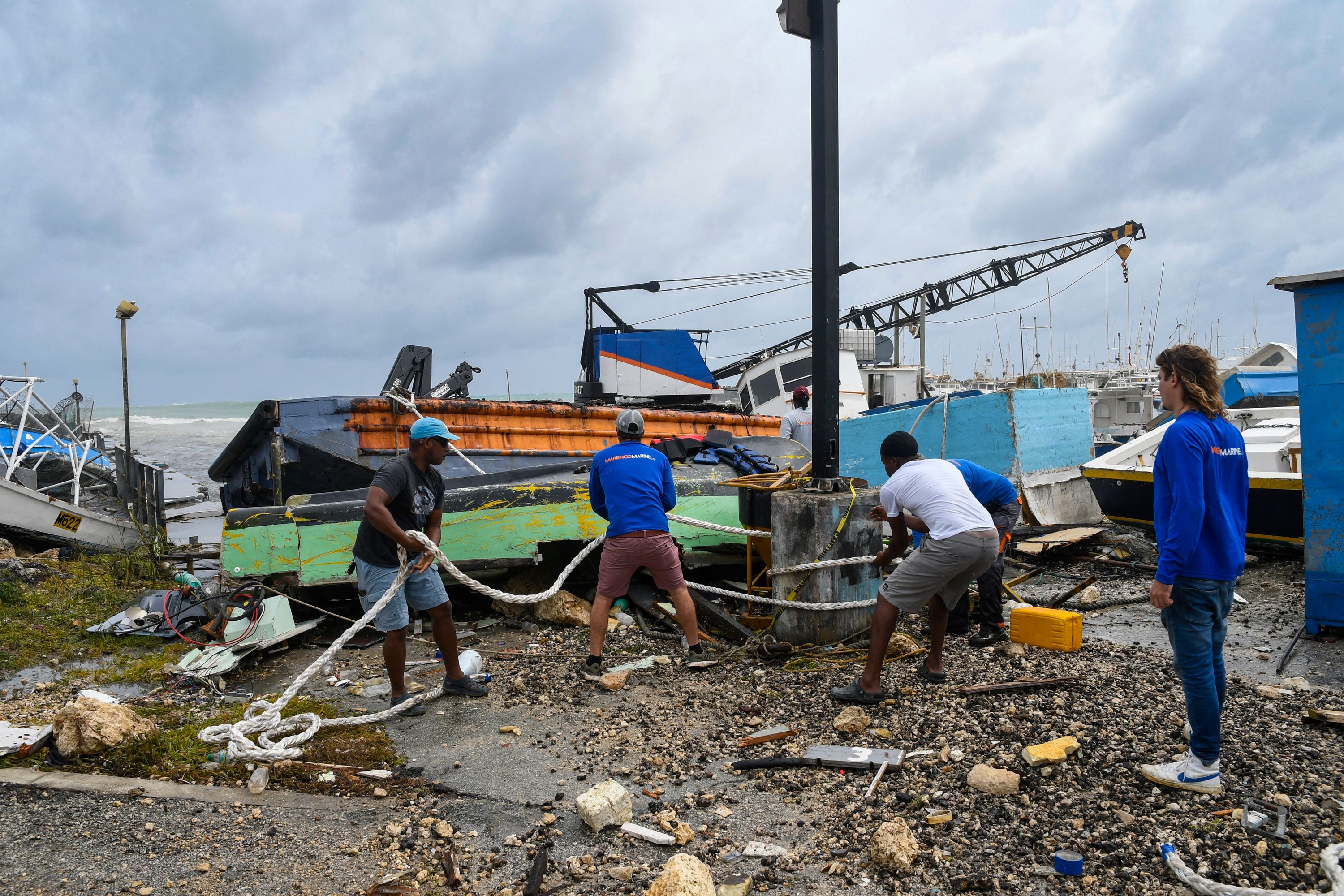 Pescadores de Bridgetown, Barbados, intentan rescatar un barco pesquero dañado tras el paso del huracán Beryl. (Foto Prensa Libre: Randy Brooks / AFP)