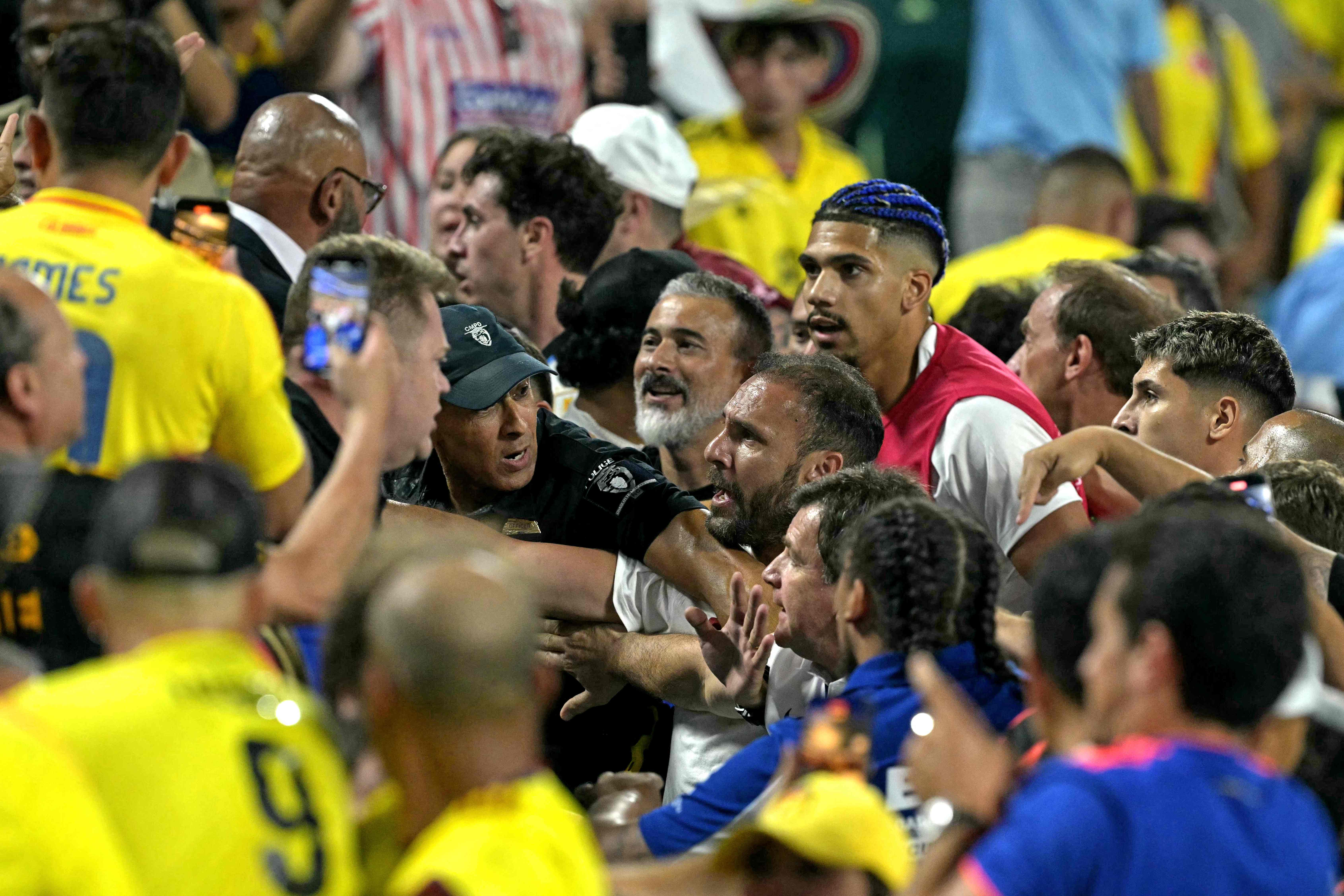 Los aficionados de Colombia (izquierda) se enfrentan con los aficionados de Uruguay, junto al defensor uruguayo #04 Ronald Araujo (derecha), al final del partido de semifinales del torneo de la Copa América Conmebol 2024 entre Uruguay y Colombia en el Bank of America Stadium, en Charlotte, Carolina del Norte, el 10 de julio de 2024.'