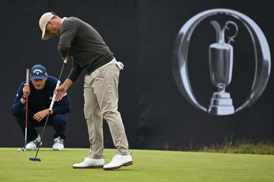 Australia's Adam Scott taps in as Denmark's Nicolai Hojgaard lines up a putt on the 17th green on the opening day of the 152nd British Open Golf Championship at Royal Troon on the south west coast of Scotland on July 18, 2024. (Photo by Paul ELLIS / AFP) / RESTRICTED TO EDITORIAL USE