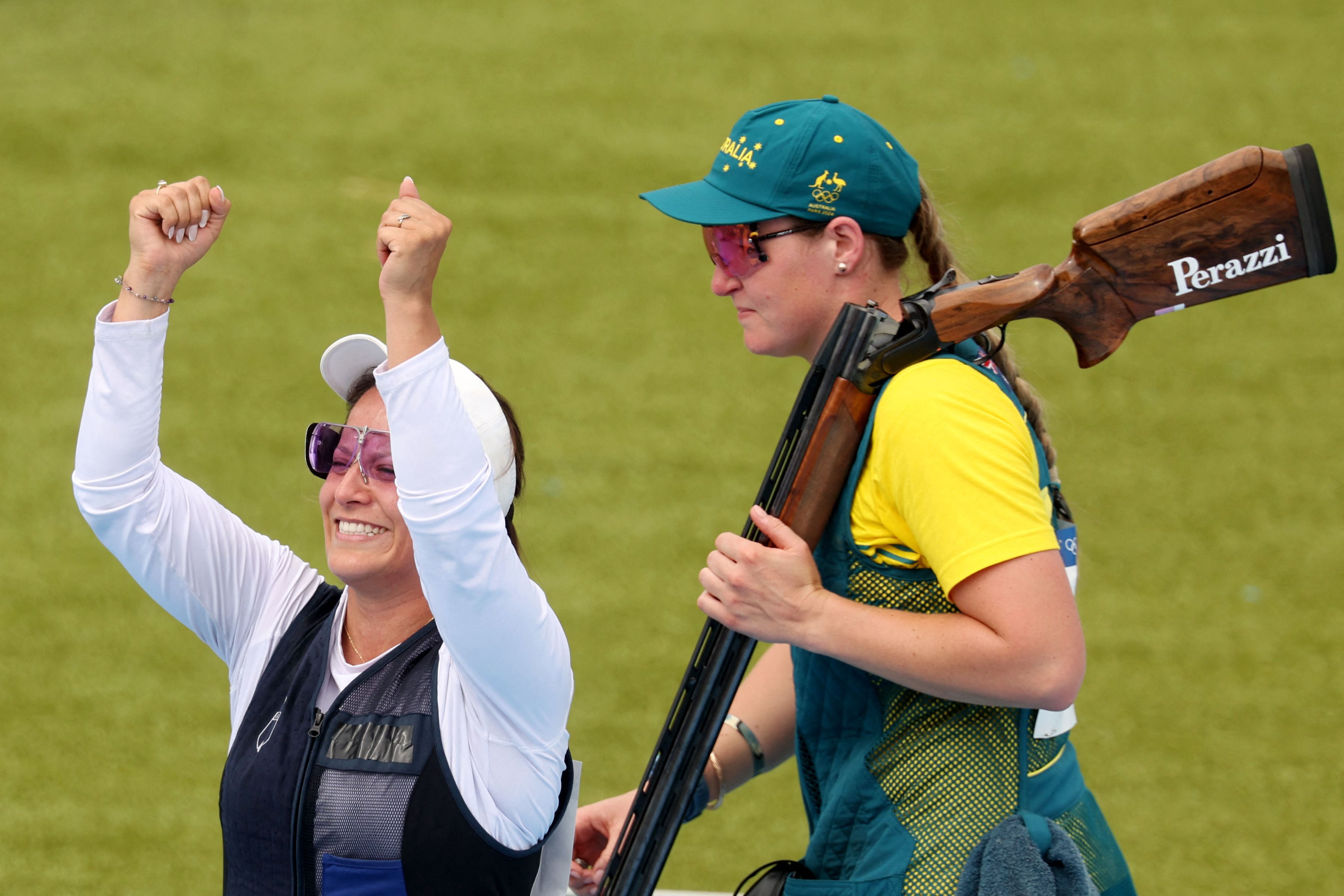 Adriana Ruano Oliva (izq.), de Guatemala, medallista de oro, y Penny Smith, de Australia, medallista de bronce, reaccionan al final de la final femenina de tiro al plato.'