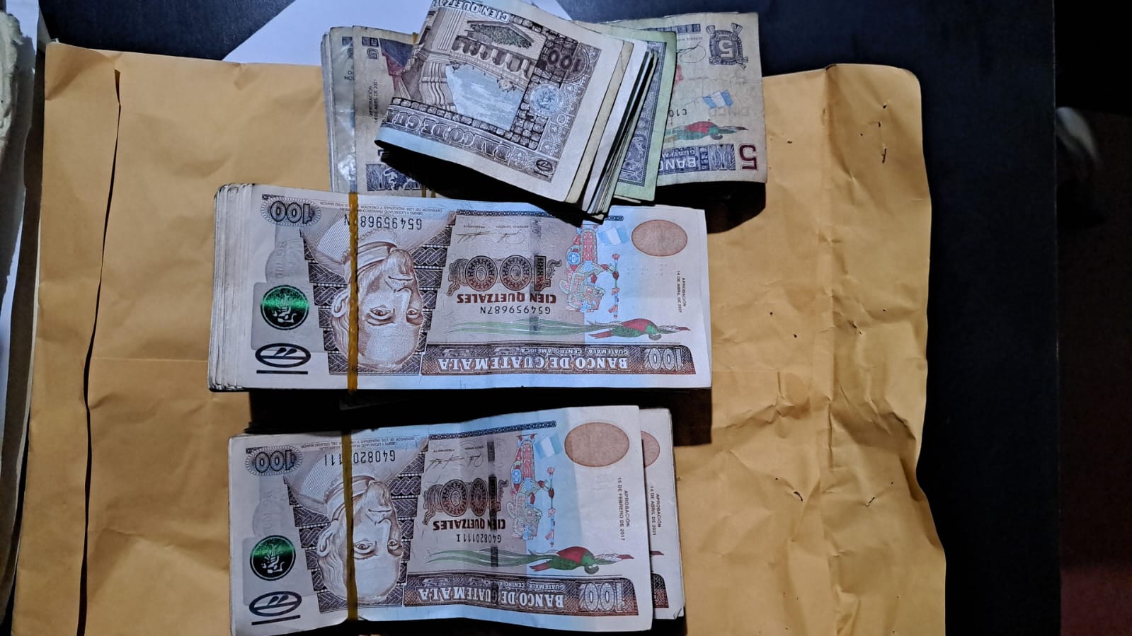 Dos supuestos cobradores colombianos tenían Q24 mil en su poder, producto de actividades ilícitas. (Foto Prensa Libre: PNC)