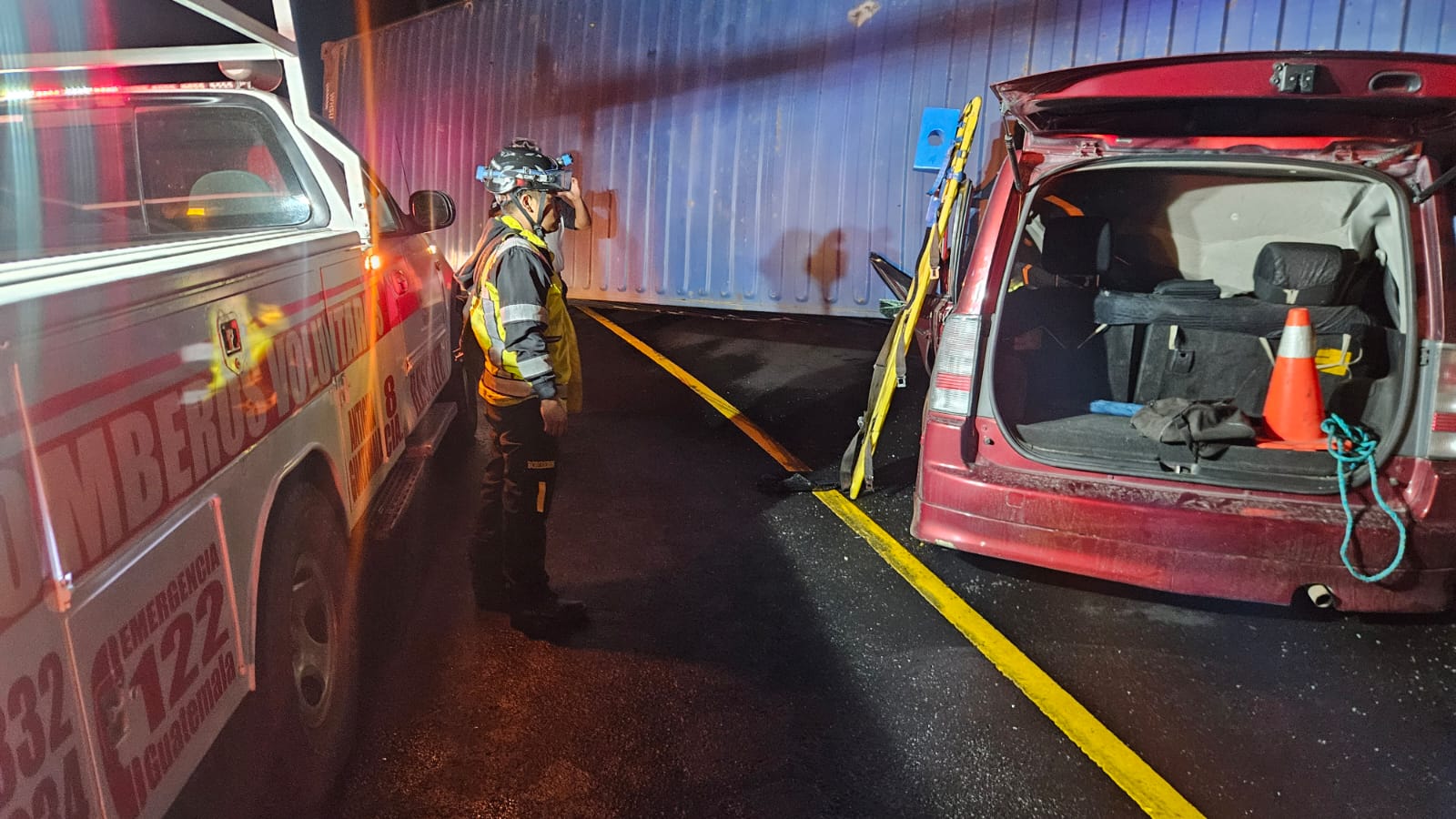 Socorristas utilizan equipo hidráulico para extraer el cadáver de una persona que murió cuando un tráiler le cayó encima. (Foto Prensa Libre: Bomberos Volunarios)