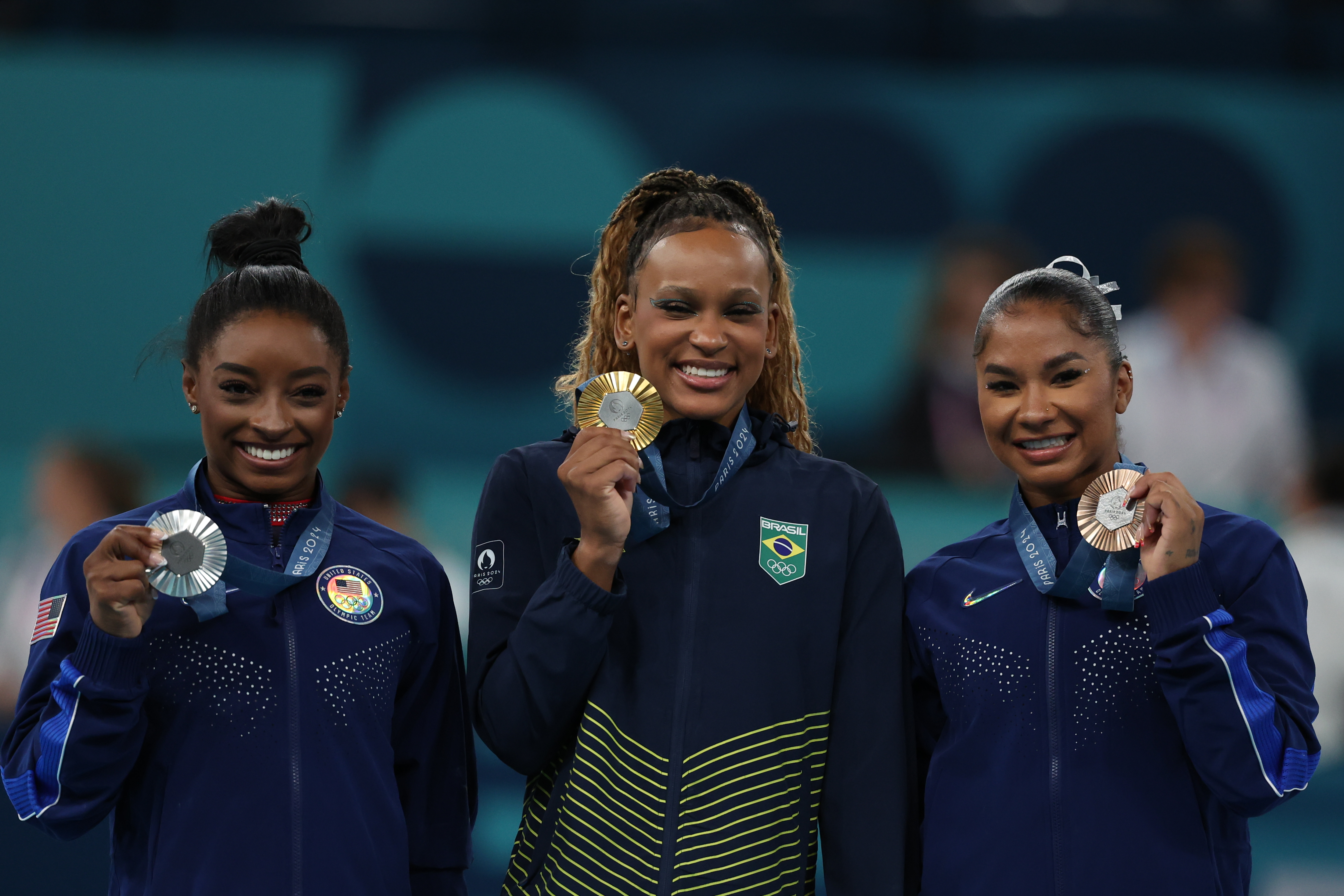 La gimnasta brasileña Rebeca Andrade (c), oro; y las estadounidense Simone Biles (i), plata, y Jordan Chiles (d), bronce, posan durante la ceremonia de entrega de medallas de la final de suelo femenino de gimnasia artística.