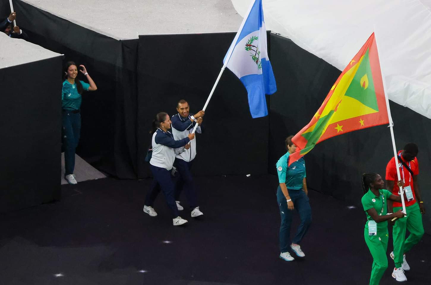 Adriana Ruano, medallista de oro para Guatemala, y el atleta Alberto González ondean con orgullo la bandera nacional durante la ceremonia de clausura de los Juegos Olímpicos de París 2024, celebrando un logro histórico para su país.