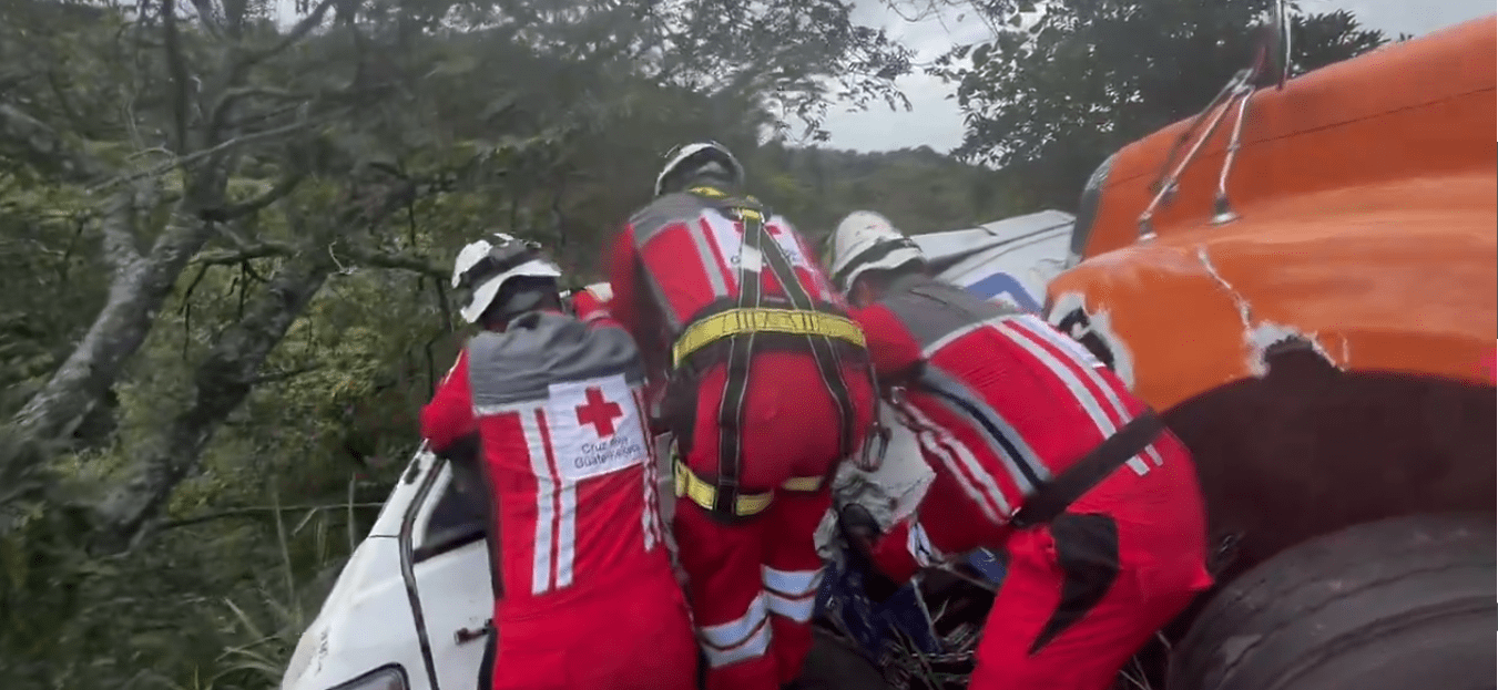 Bomberos rescatan a un hombre que quedó atrapado en un accidente entre un microbús y un tráiler en la RN – 14. (Foto Prensa Libre: Cruz Roja Guatemalteca)