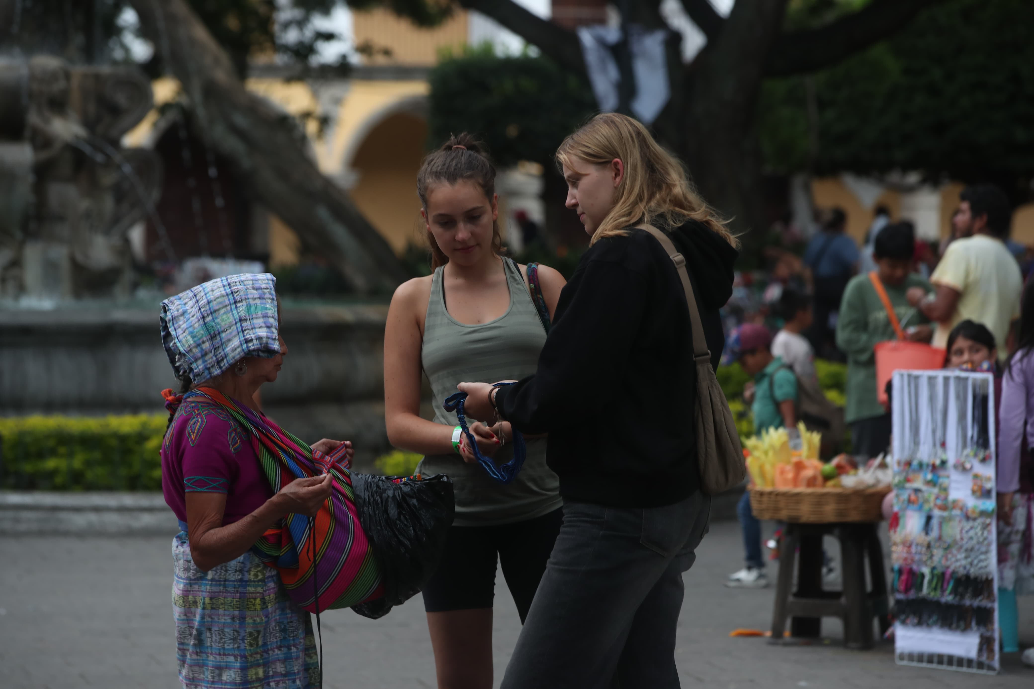 Dos turistas comprando recuerdos en el Parque Central de la Antigua Guatemala