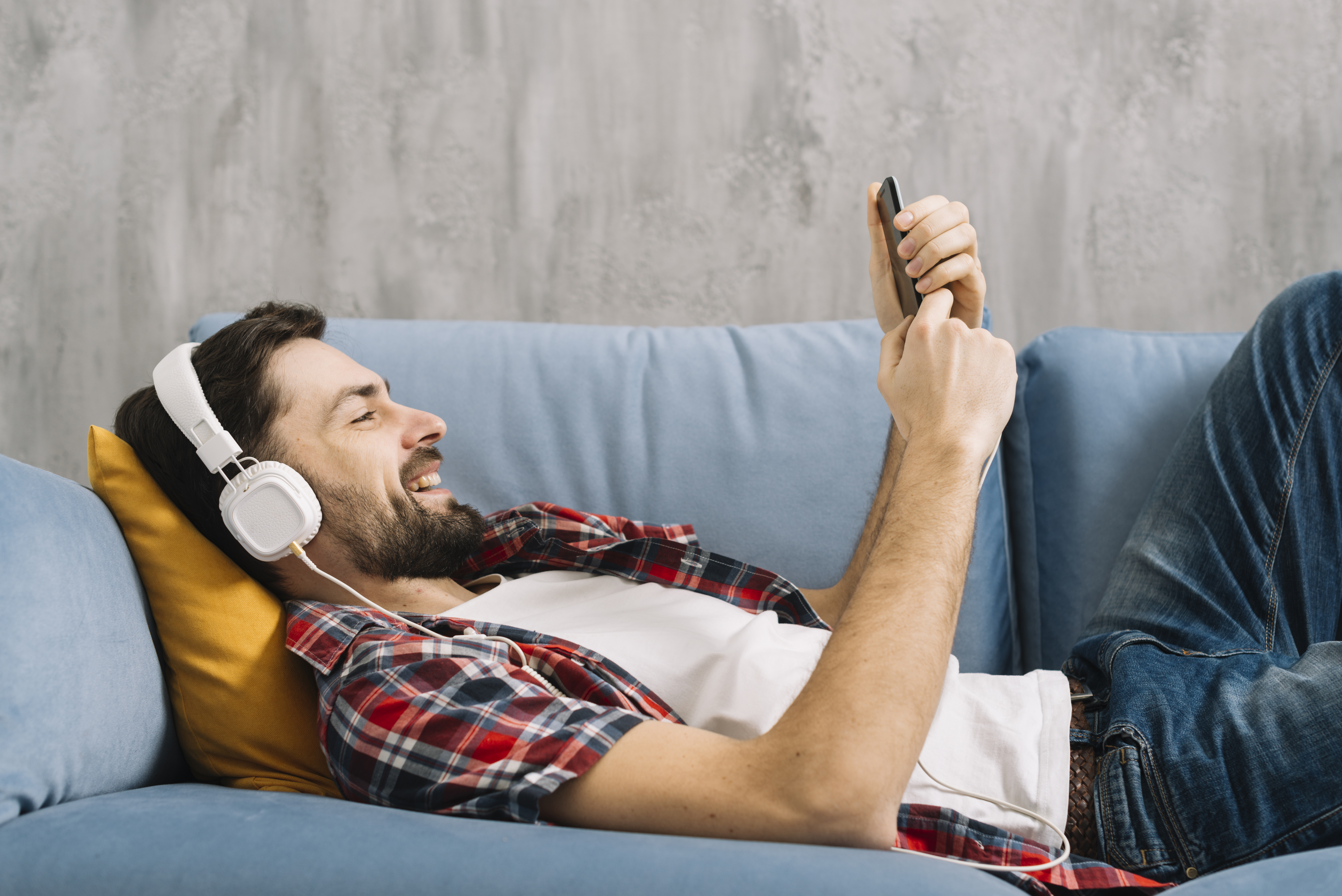 hombre recostado en un sofá buscando una distracción para el fin de semana