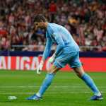 El portero del Real Madrid Thibaut Courtois retira un objeto lanzado desde la grada, durante el partido entre Atlético de Madrid y Real Madrid.