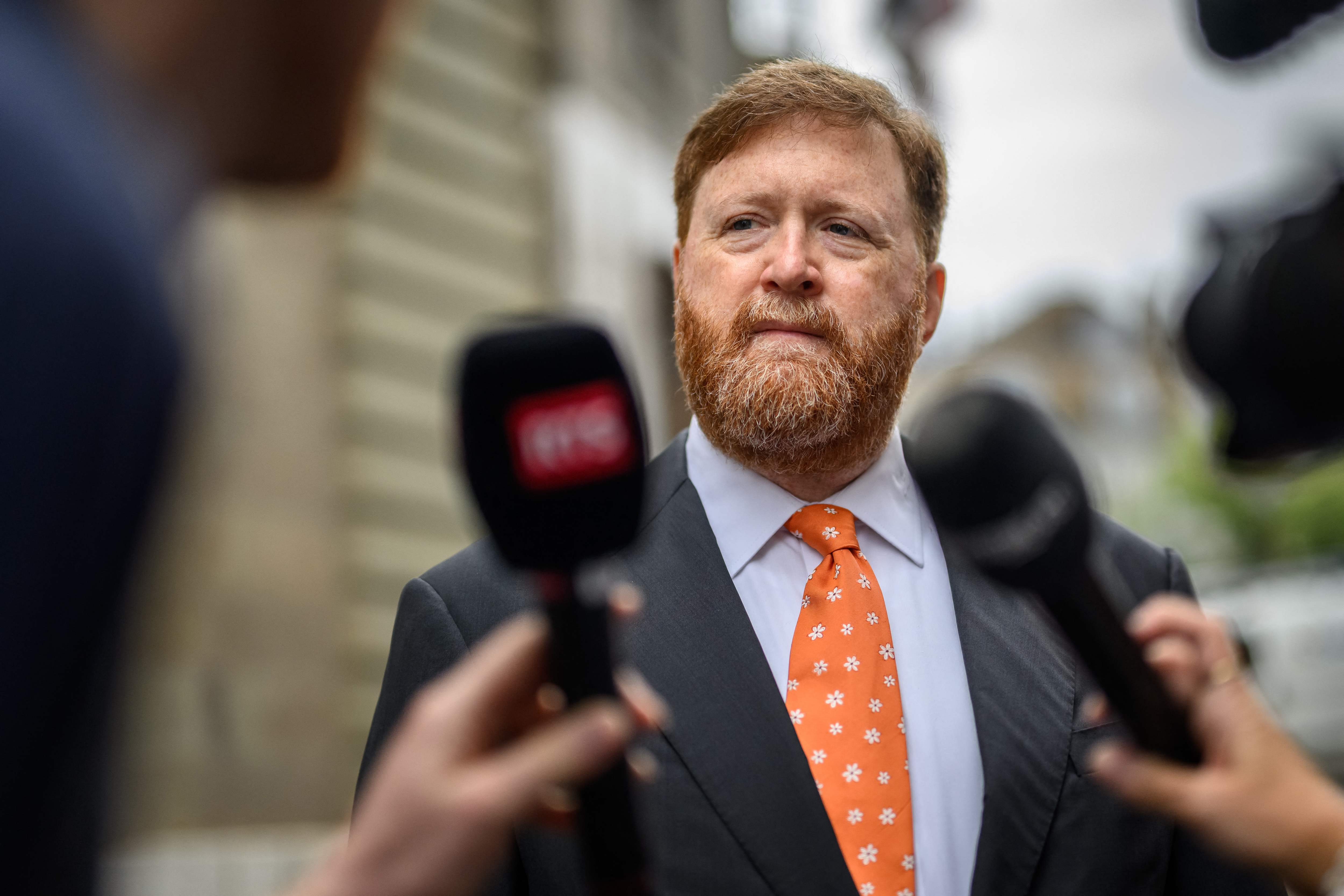 Guatemala's former police chief Erwin Sperisen answers questions to journalists upon his arrival at the Geneva's court house for the opening of his fourth trial in Geneva on September 2, 2024. Sperisen, a Guatemalan and Swiss dual national who had been found guilty and sentenced to 15 years for complicity in the murders of seven prisoners in Pavon jail in September 2006 has to be retried after Switzerland's highest court overturned his conviction. (Photo by Fabrice COFFRINI / AFP)