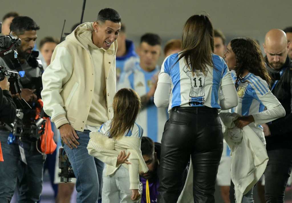 Ángel Di María conversa con sus hijas Pía y Mia, y su esposa Jorgelina Cardoso, durante un homenaje tras retirarse de la selección argentina. 