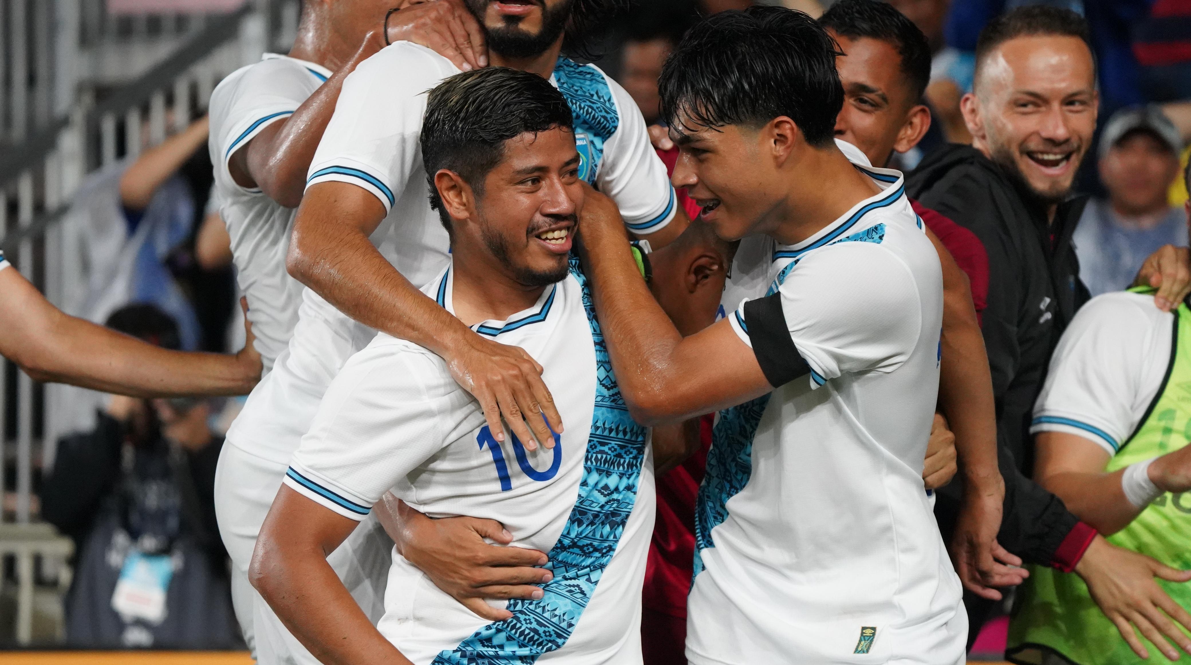 Pedro Altán celebra junto a Olger Escobar el gol de Guatemala frente a Uruguay.