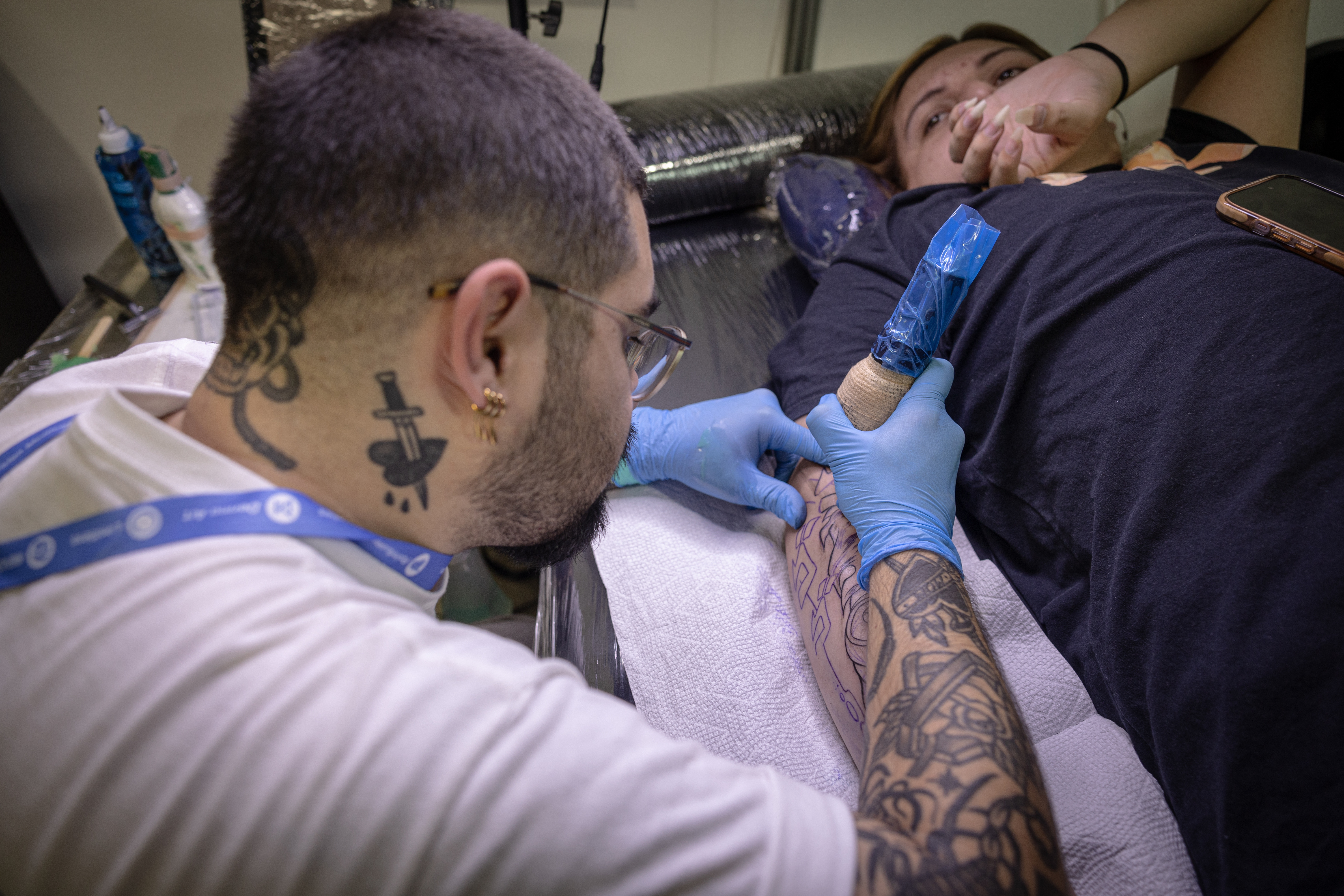 AME3444. CIUDAD DE GUATEMALA (GUATEMALA), 28/09/2024.- Un tatuador trabaja en el brazo de una persona, durante una convención de tatuadores este sábado en Ciudad de Guatemala (Guatemala). Más de un centenar de tatuadores de todo el continente americano participan este sábado en una convención en la Ciudad de Guatemala, donde comparten su arte con cientos de visitantes por medio de muchos diseños diferentes y charlas informativas. EFE/David Toro