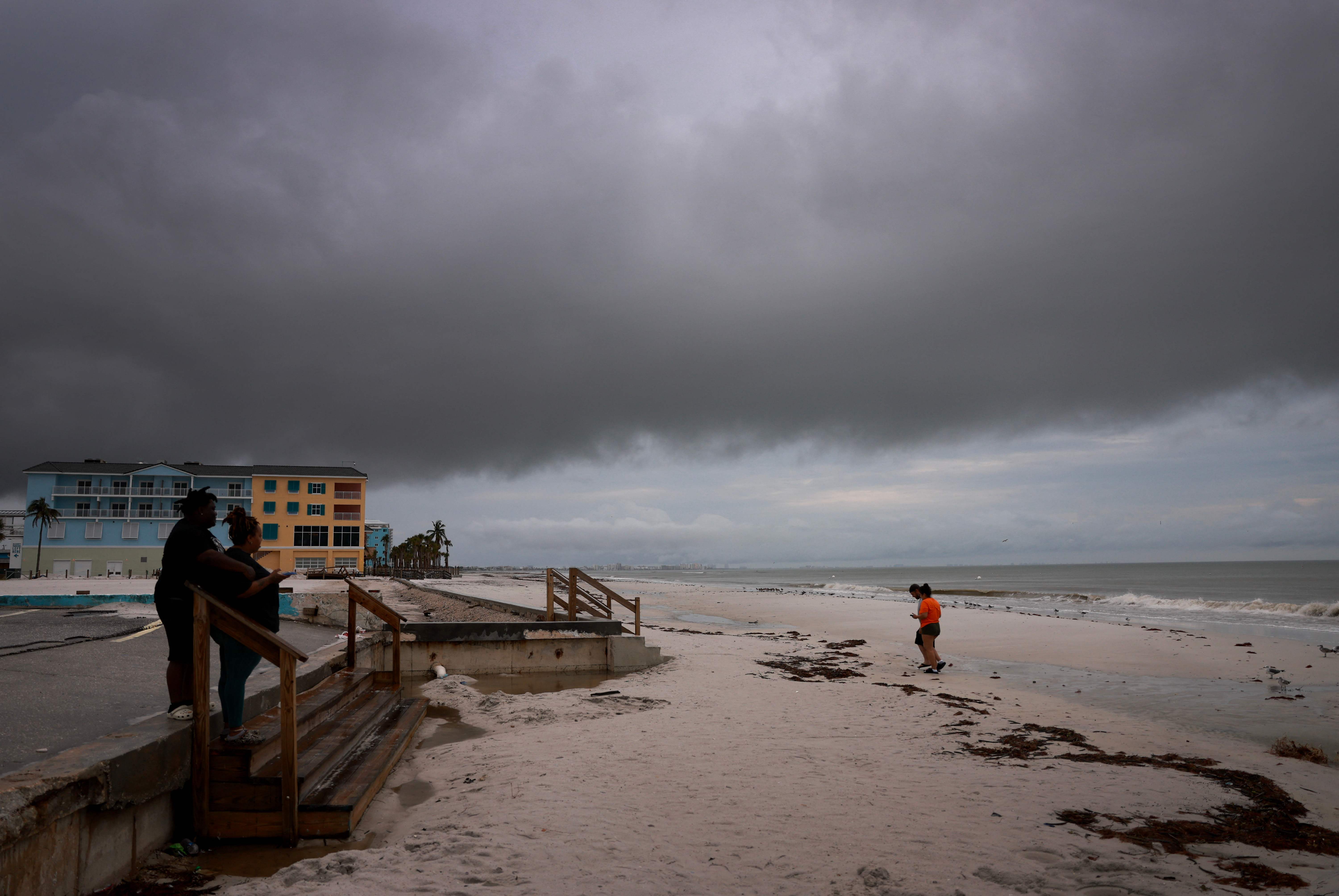 FORT MYERS, FLORIDA - OCTOBER 08: People visit the beach as storm clouds hang pass overhead before Hurricane Milton's arrival on October 08, 2024 in Fort Myers, Florida. People are preparing for the storm, which could be a Cat 3 when it makes landfall on Wednesday evening.   Joe Raedle/Getty Images/AFP (Photo by JOE RAEDLE / GETTY IMAGES NORTH AMERICA / Getty Images via AFP)