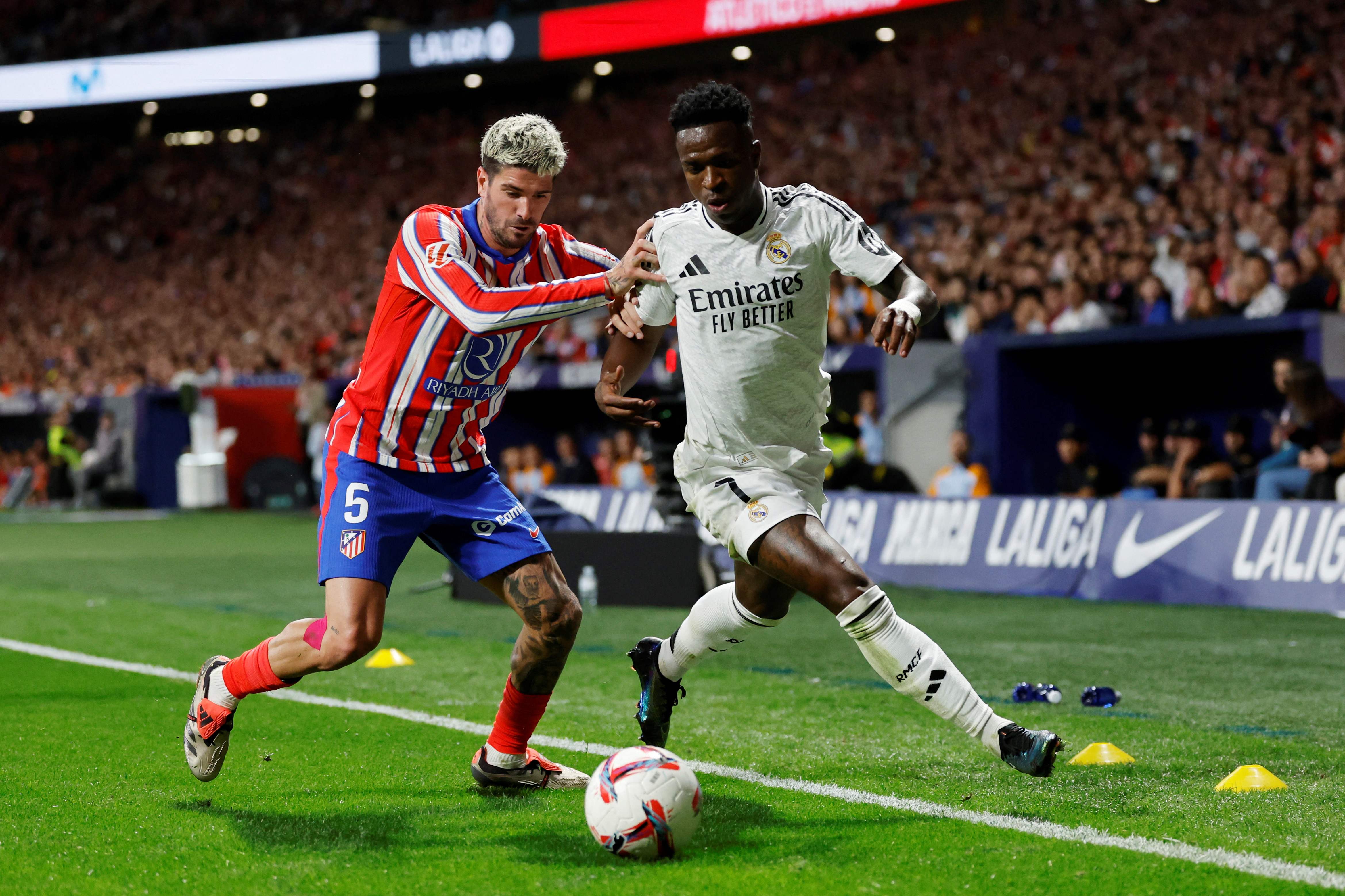Vinícius Junior lucha por el balón contra Rodrigo De Paul.