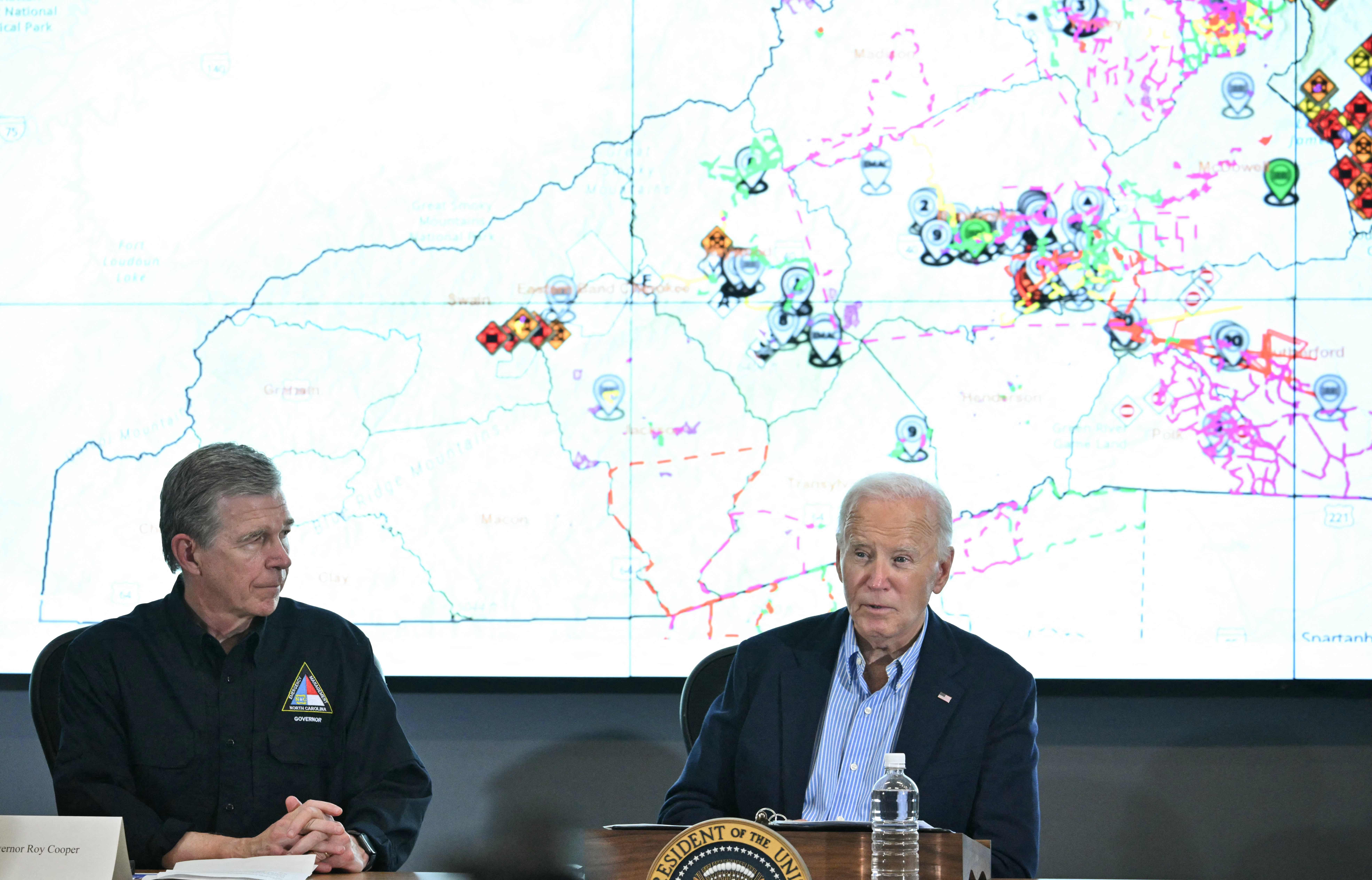 North Carolina governor Roy Cooper (L) listens as US President Joe Biden speaks during an Operational Briefing at Raleigh Emergency Operations Center following the passage of Hurricane Helene, in Raleigh, North Carolina, on October 2, 2024. The death toll from powerful storm Helene, which battered the southeastern United States, has climbed to at least 155, authorities said on October 1. (Photo by Mandel NGAN / AFP)