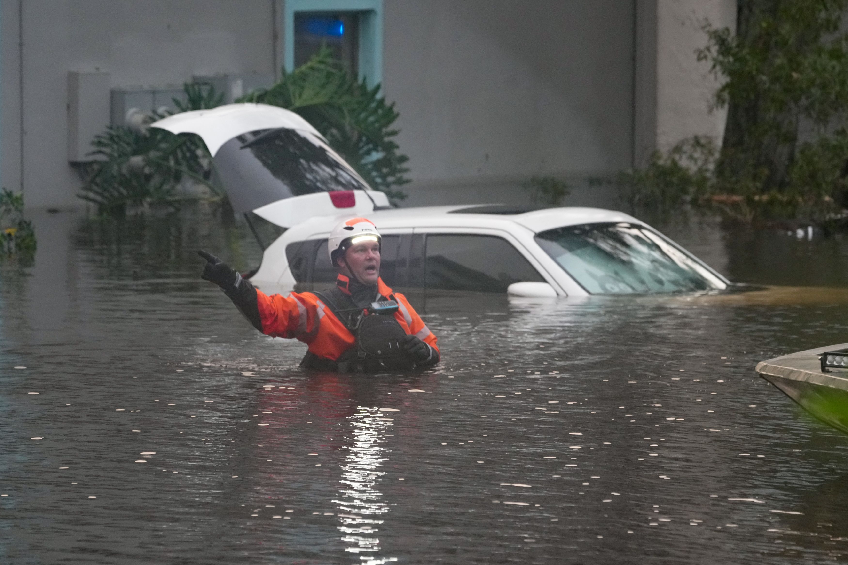 Socorristas en el agua afuera de un complejo de apartamentos que se inundó y se desbordó debido al huracán Milton en Florida.