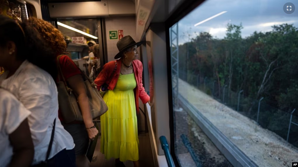 ARCHIVO - Un pasajero observa el paisaje selvático que pasa mientras viaja en el Tren Maya de Cancún a Valladolid, México, el 6 de marzo de 2024. (VOA)