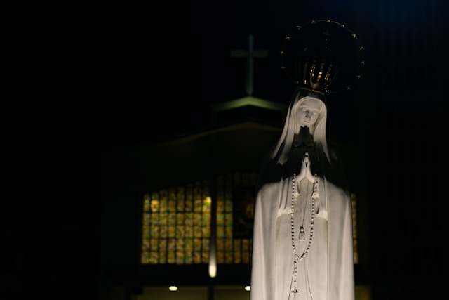 Imagen de la Virgen de Fátima cerca de un templo.