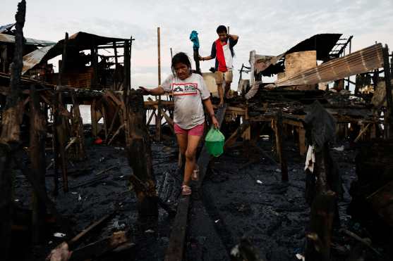 Manila (Philippines), 25/11/2024.- Residents carry recovered belongings after a fire broke out in Manila, Philippines, 25 November 2024. A fire broke out in a slum area in Manila, and several families were left homeless. In Shanty Town, most of the homes are made of combustible materials. (Filipinas) EFE/EPA/FRANCIS R. MALASIG