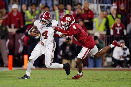 NORMAN, OKLAHOMA - NOVEMBER 23: Quarterback Jalen Milroe #4 of the Alabama Crimson Tide is tackled by defensive back Dez Malone #4 of the Oklahoma Sooners in the third quarter at Gaylord Family Oklahoma Memorial Stadium on November 23, 2024 in Norman, Oklahoma. Oklahoma won 24-3.   Brian Bahr/Getty Images/AFP (Photo by BRIAN BAHR / GETTY IMAGES NORTH AMERICA / Getty Images via AFP)