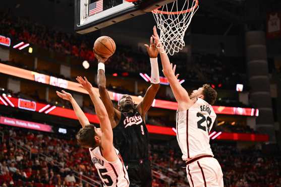 HOUSTON, TEXAS - NOVEMBER 23: Reed Sheppard #15 of the Houston Rockets fouls Jerami Grant #9 of the Portland Trail Blazers as Alperen Sengun of the Houston Rockets defends during the second quarter at Toyota Center on November 23, 2024 in Houston, Texas. NOTE TO USER: User expressly acknowledges and agrees that, by downloading and or using this photograph, User is consenting to the terms and conditions of the Getty Images License Agreement.   Jack Gorman/Getty Images/AFP (Photo by Jack Gorman / GETTY IMAGES NORTH AMERICA / Getty Images via AFP)