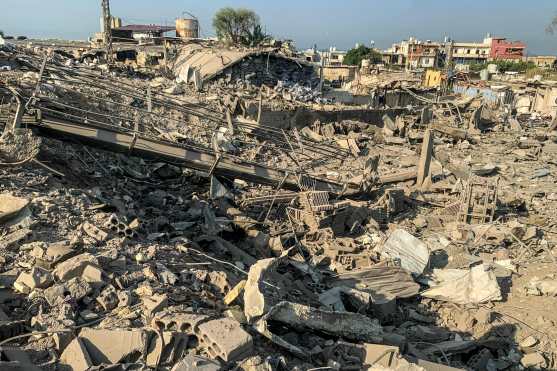 Men walk through the rubble at the site of an Israeli airstrike targeting the Ouzai neighborhood near Beirut International Airport in the citys southern suburbs on November 7, 2024. Israel launched fresh strikes on south Beirut early November 7, hours after Prime Minister Benjamin Netanyahu and US president-elect Donald Trump spoke about the "Iranian threat". (Photo by AFP)