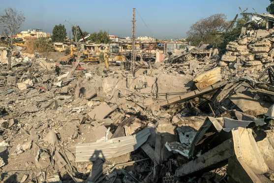 Men walk through the rubble at the site of an Israeli airstrike targeting the Ouzai neighborhood near Beirut International Airport in the citys southern suburbs on November 7, 2024. Israel launched fresh strikes on south Beirut early November 7, hours after Prime Minister Benjamin Netanyahu and US president-elect Donald Trump spoke about the "Iranian threat". (Photo by AFP)