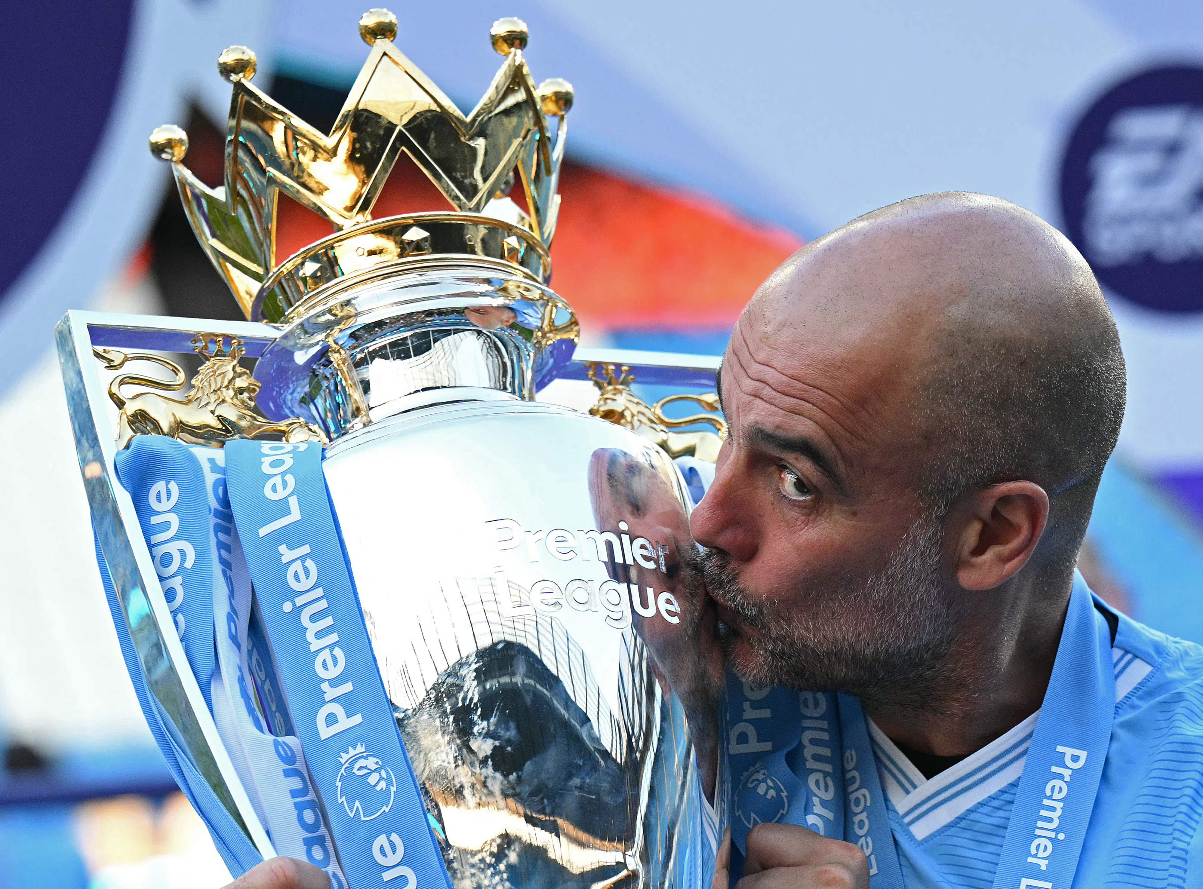 Pep Guardiola besa uno de los trofeos de Premier League que ha conquistado como entrenador del Manchester City, equipo con el que recién renovó.