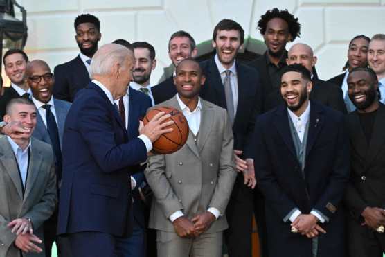 Players Al Horford, Jayson Tatum and Jaylen Brown react as US President Joe Biden holds a basketball during a welcoming event for the 2024 NBA Champions Boston Celtics to the White House in Washington, DC, during a ceremony on the South Lawn, November 21, 2024. (Photo by ROBERTO SCHMIDT / AFP)